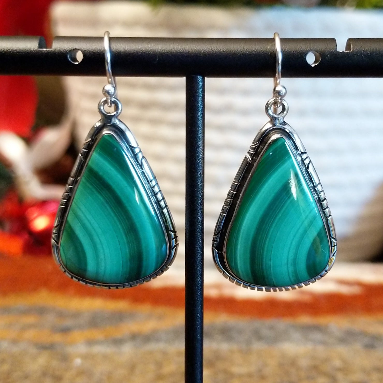 Triangular sterling silver malachite earrings framed by a stamped bezel.