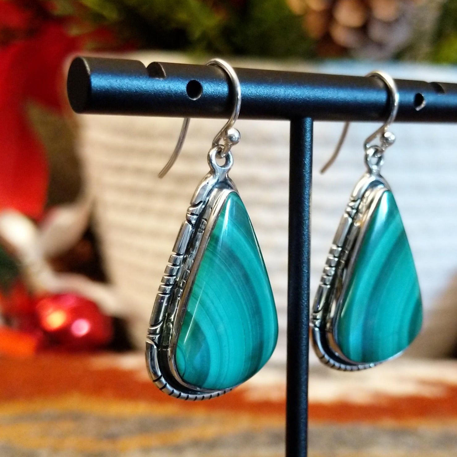Triangular sterling silver malachite earrings framed by a stamped bezel.