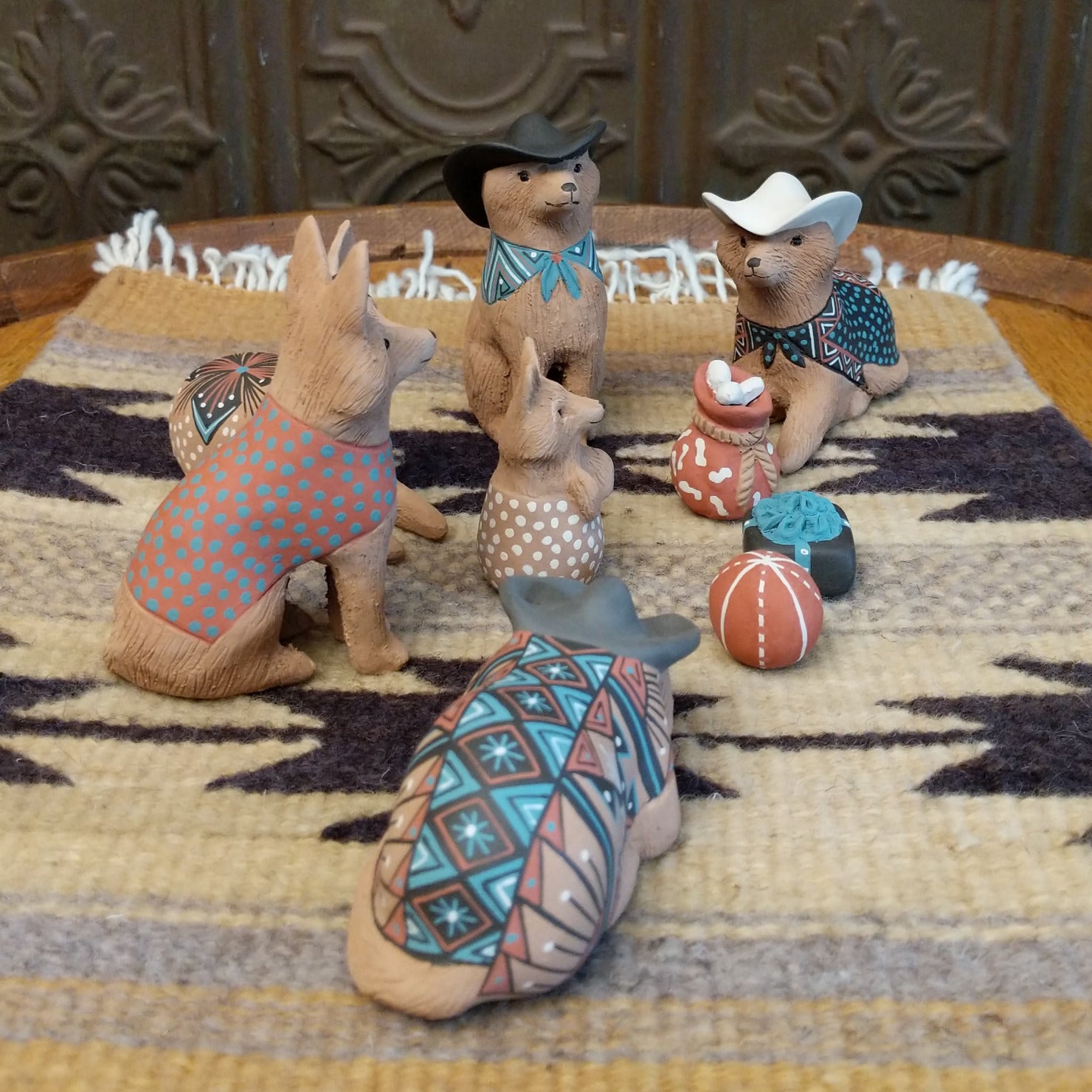 Clay sculpted into individual coyote pieces that form a nativity scene and are painted in various, colorful designs.