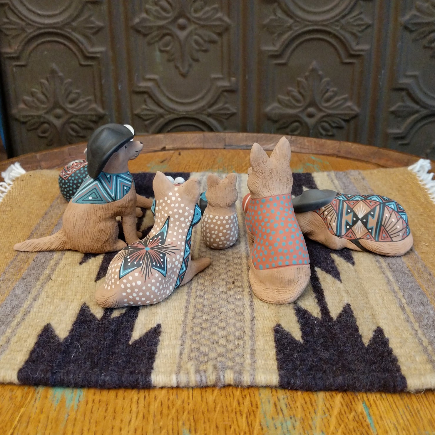 Clay sculpted into individual coyote pieces that form a nativity scene and are painted in various, colorful designs.