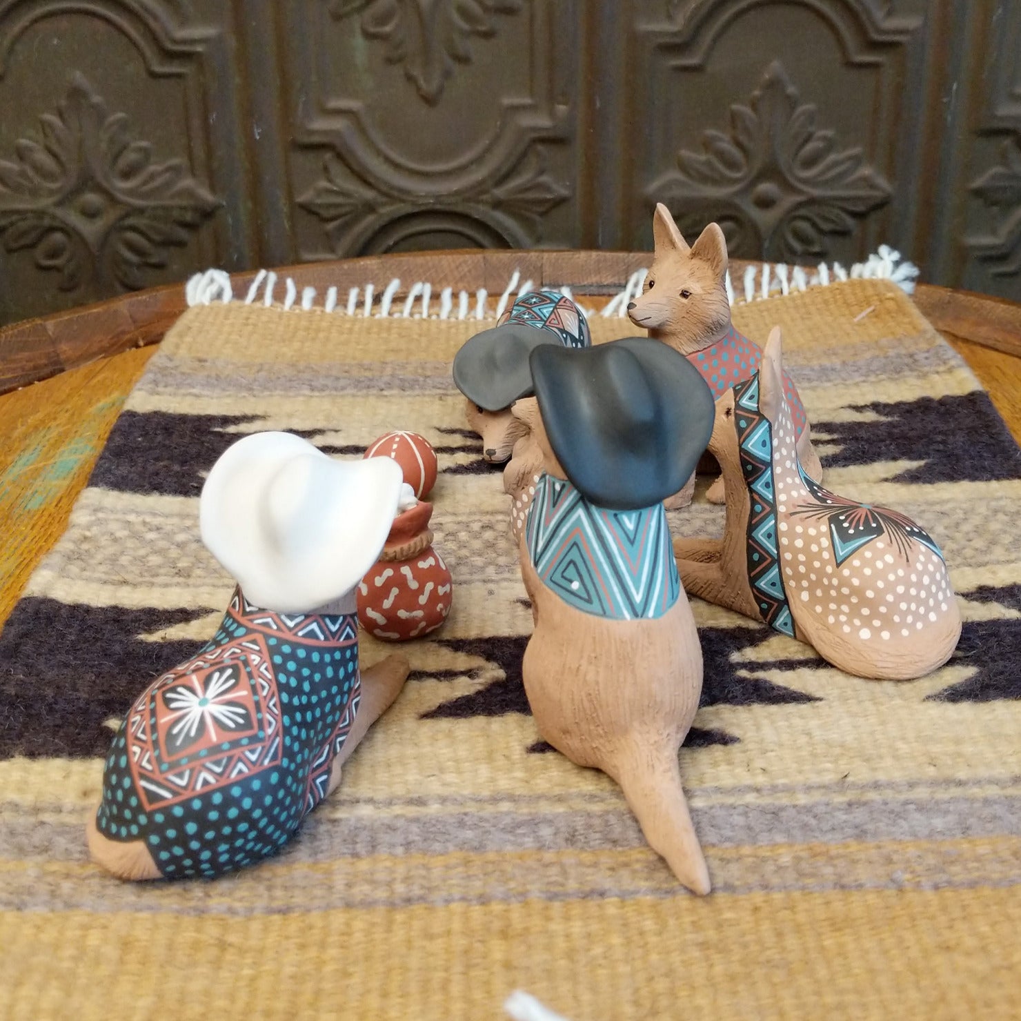 Clay sculpted into individual coyote pieces that form a nativity scene and are painted in various, colorful designs.