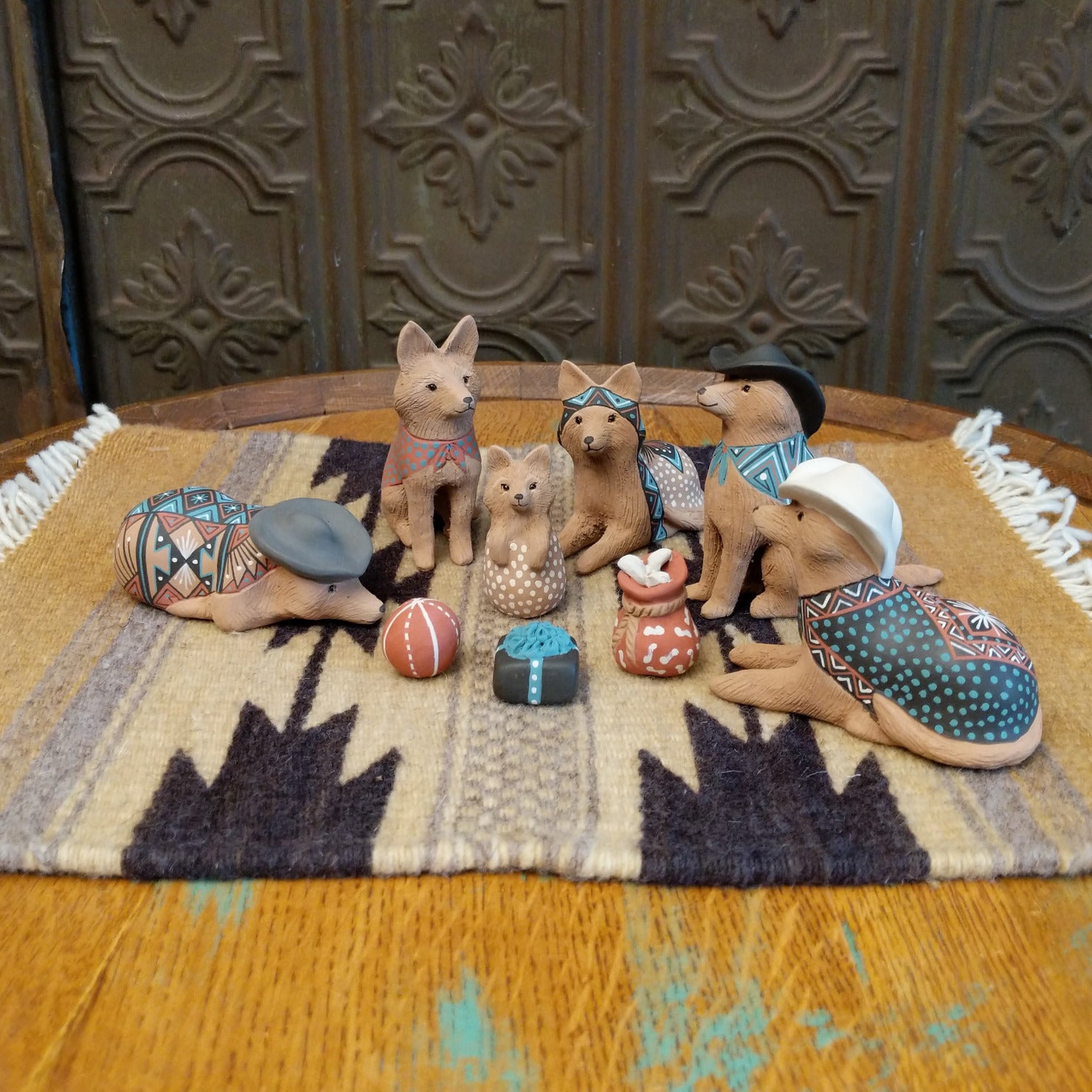Clay sculpted into individual coyote pieces that form a nativity scene and are painted in various, colorful designs.