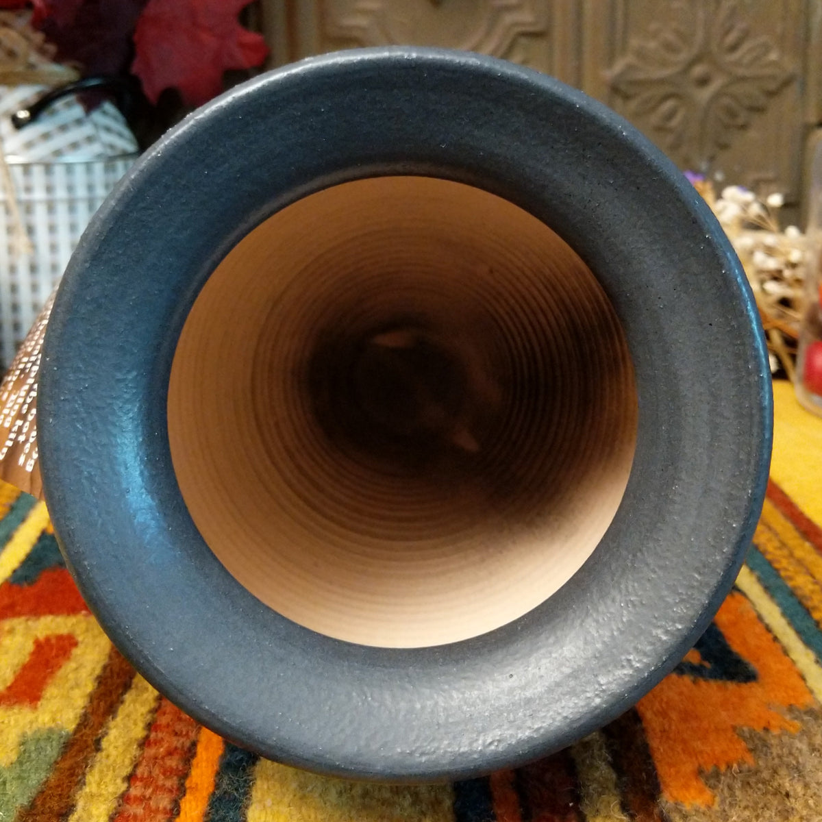 Horsehair pottery vase by Roger Calhoun with a wide flared black rim, metallic blue crackled band, and fine black horsehair patterns across a cream-colored body.