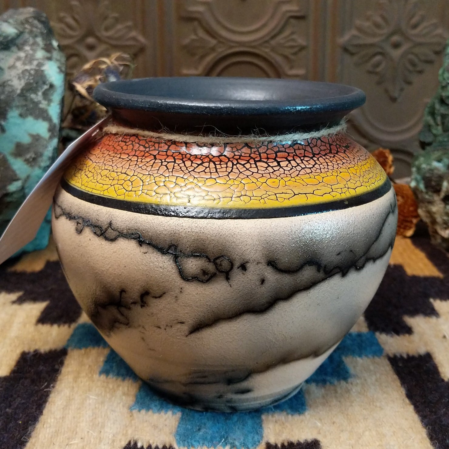 Ceramic pottery piece with horsehair fired onto the surface and sunset-colored top-half with crackled finish.