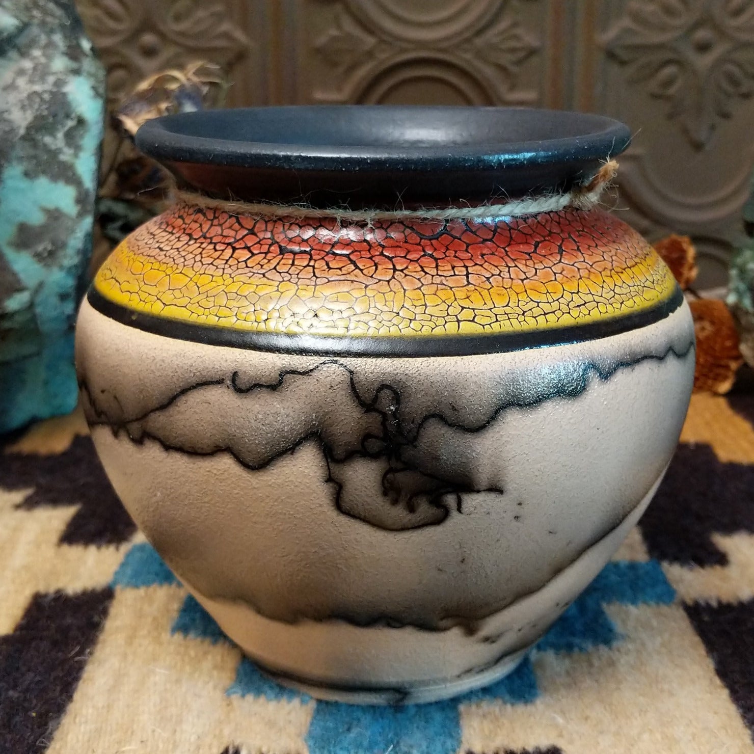 Ceramic pottery piece with horsehair fired onto the surface and sunset-colored top-half with crackled finish.