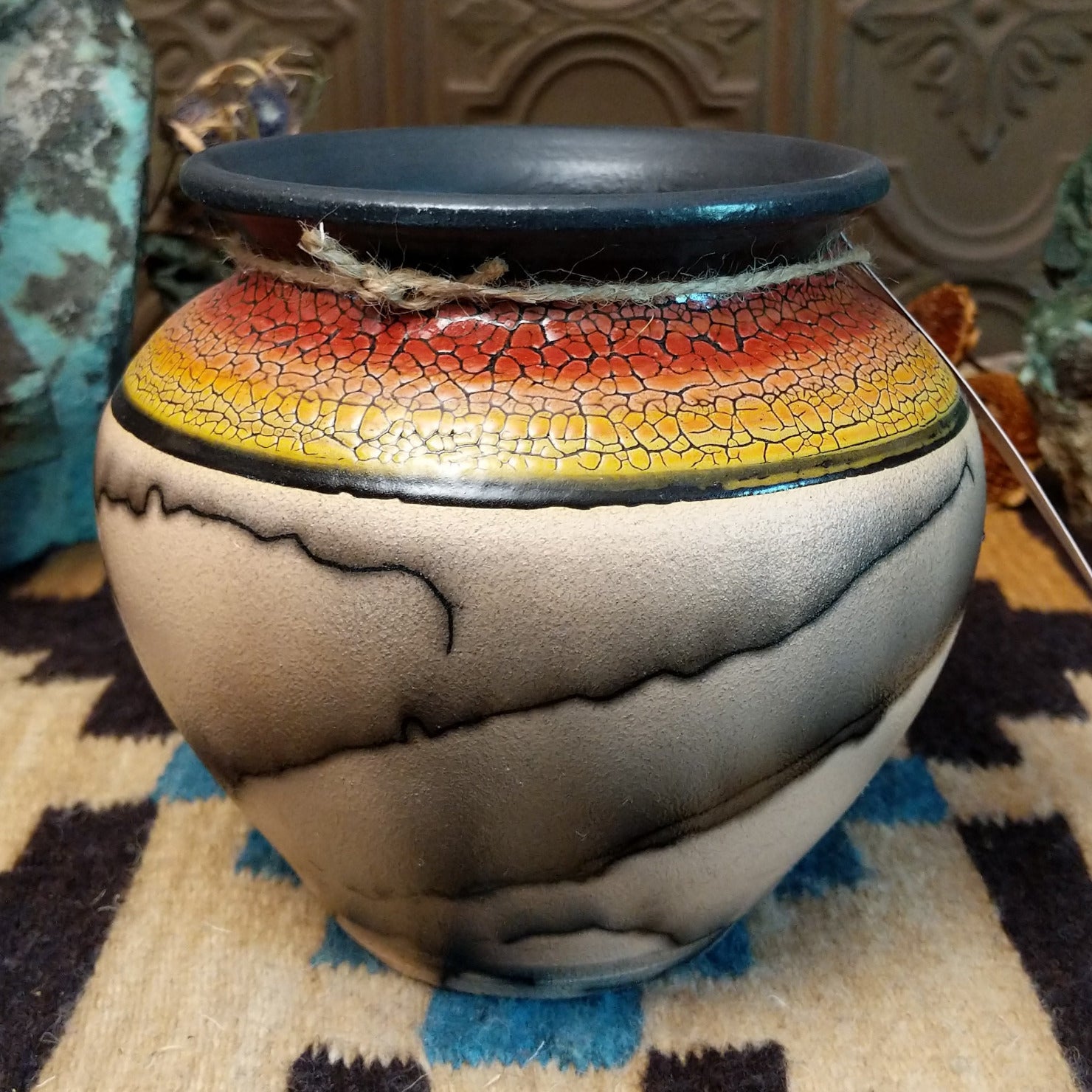 Ceramic pottery piece with horsehair fired onto the surface and sunset-colored top-half with crackled finish.
