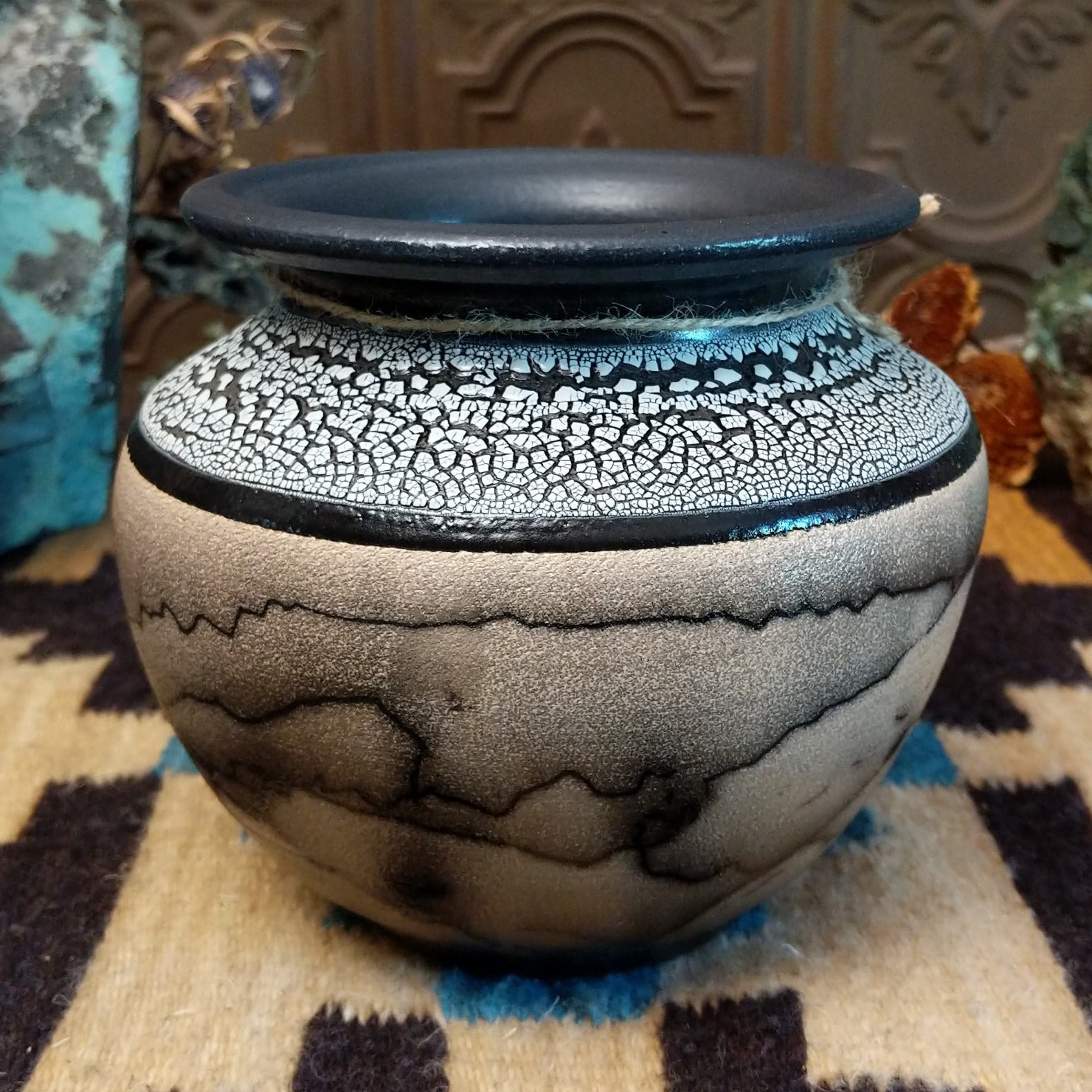 Ceramic pottery piece with horsehair fired onto the surface and white crackled glaze on the top-half.