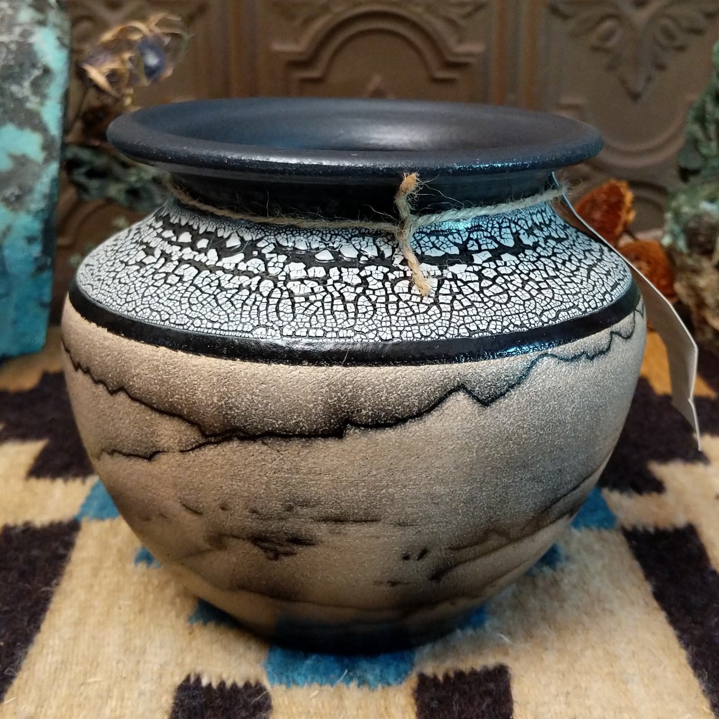 Ceramic pottery piece with horsehair fired onto the surface and white crackled glaze on the top-half.