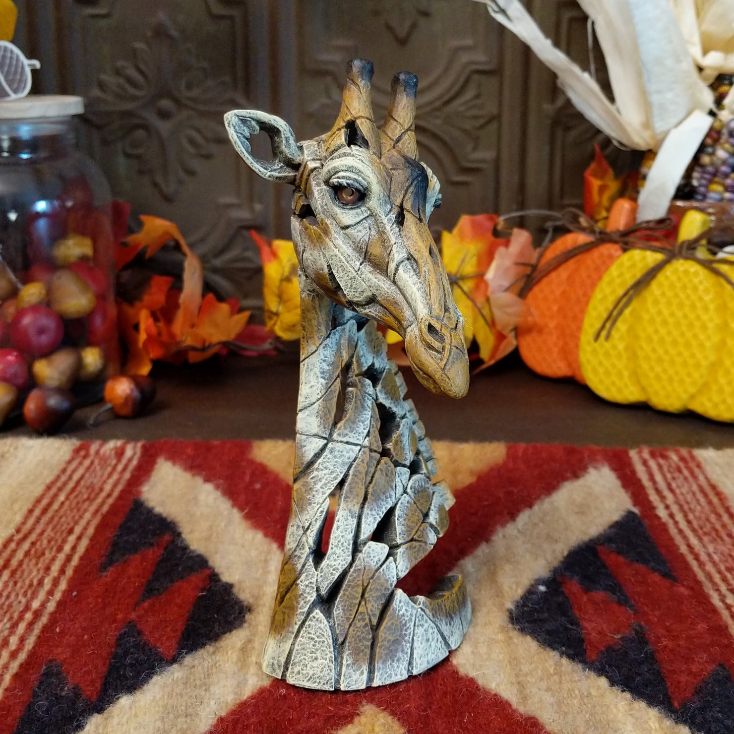 Cast marble used to create a miniature giraffe head painted in traditional colors representing the animal.