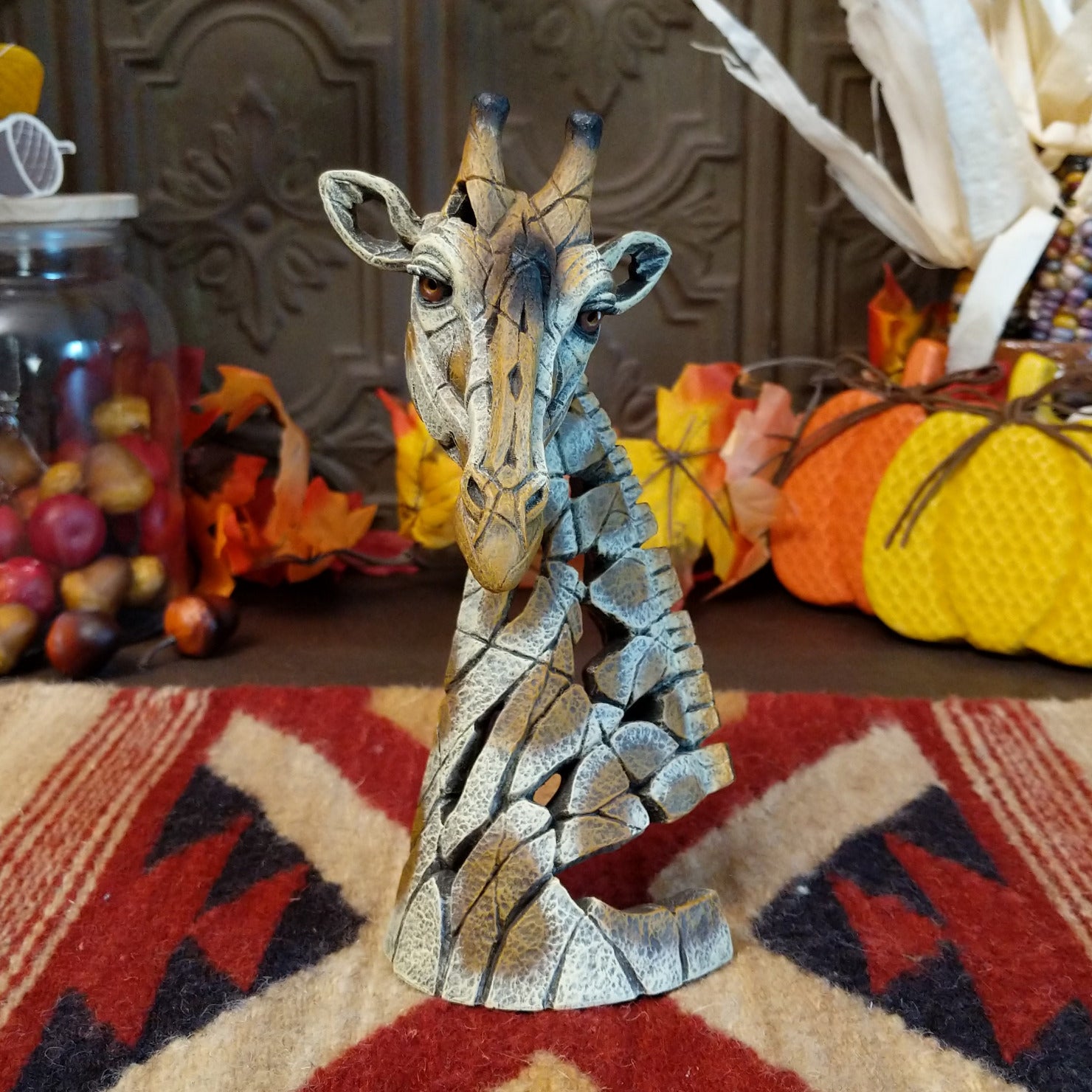 Cast marble used to create a miniature giraffe head painted in traditional colors representing the animal.