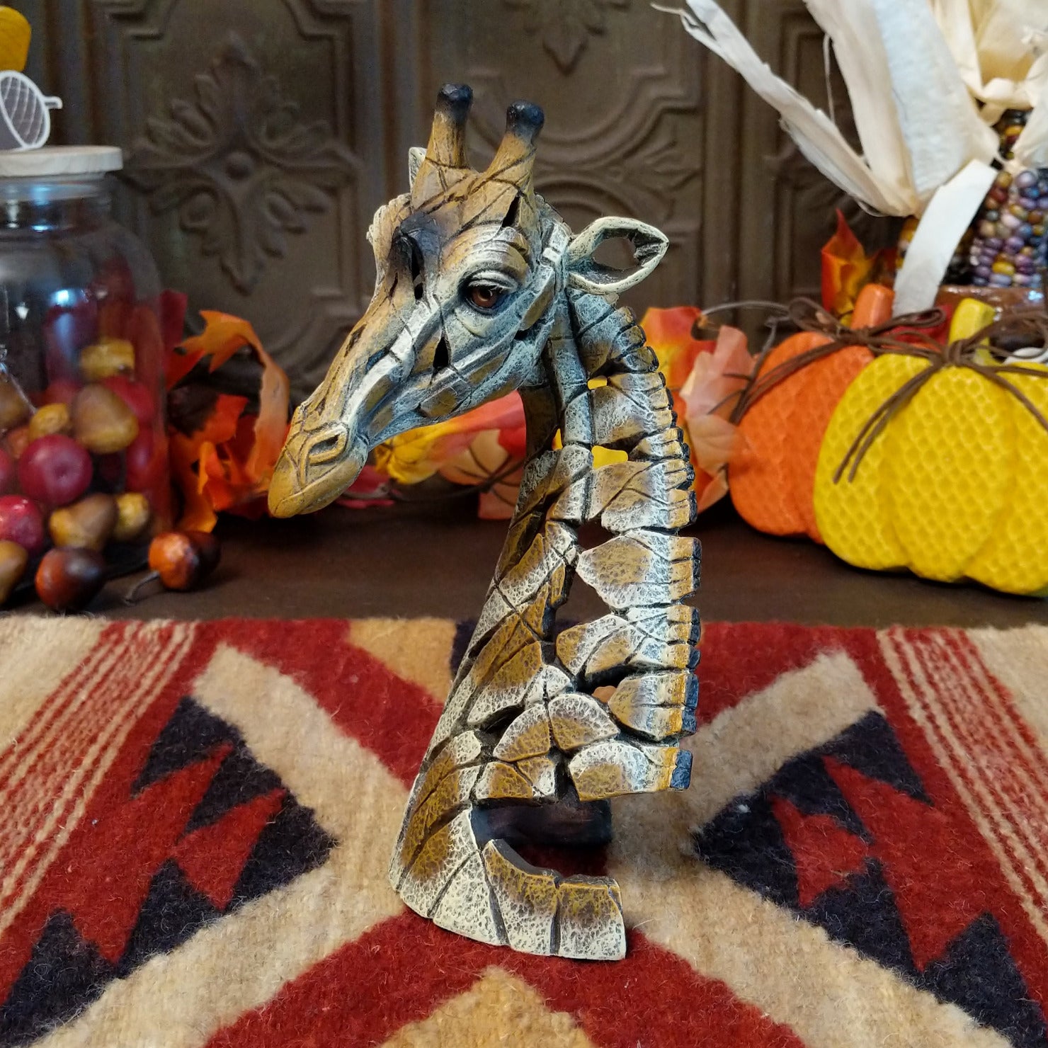 Cast marble used to create a miniature giraffe head painted in traditional colors representing the animal.
