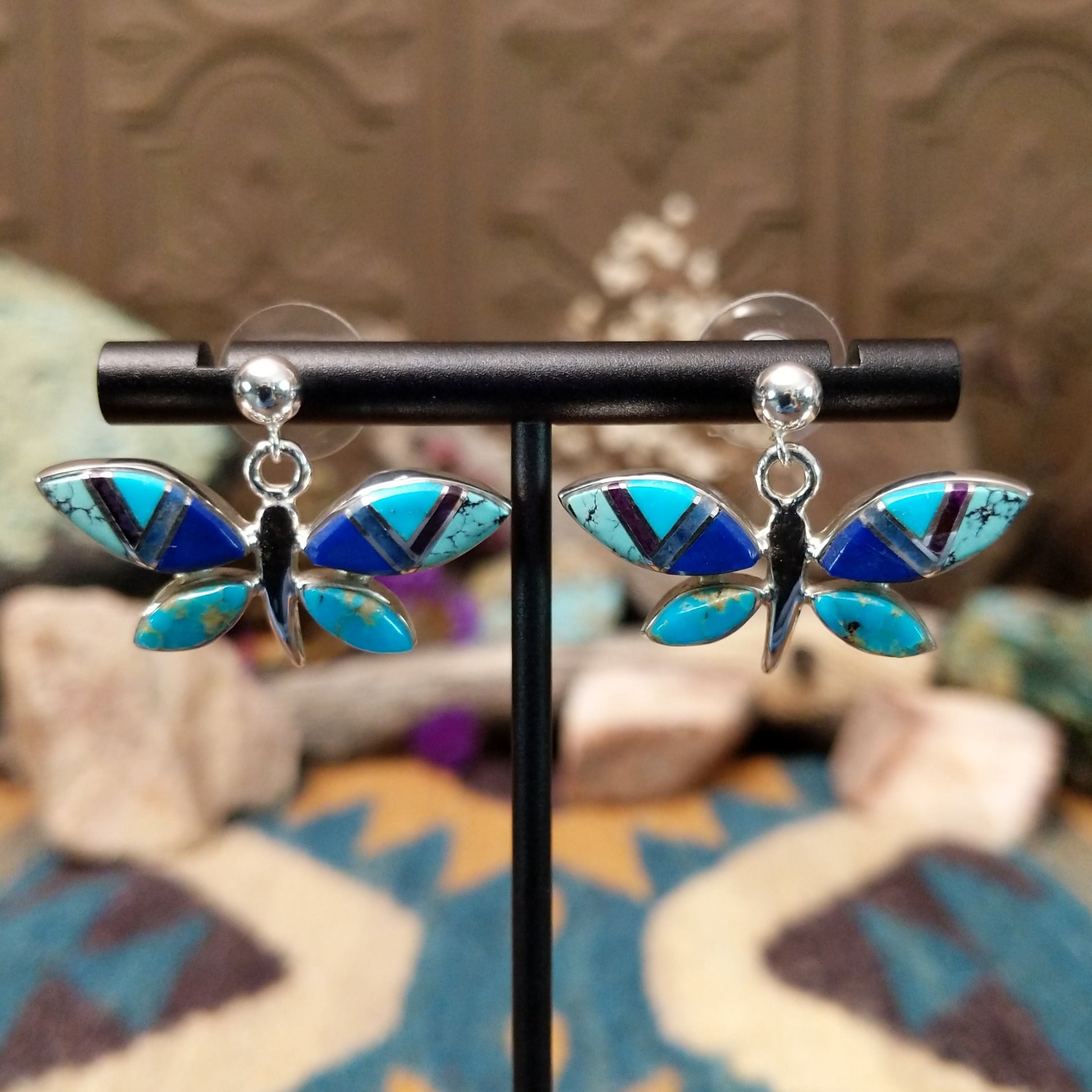 Handcrafted Navajo sterling silver dragonfly earrings by O. James featuring colorful multistone inlay wings in a polished silver dangle design.