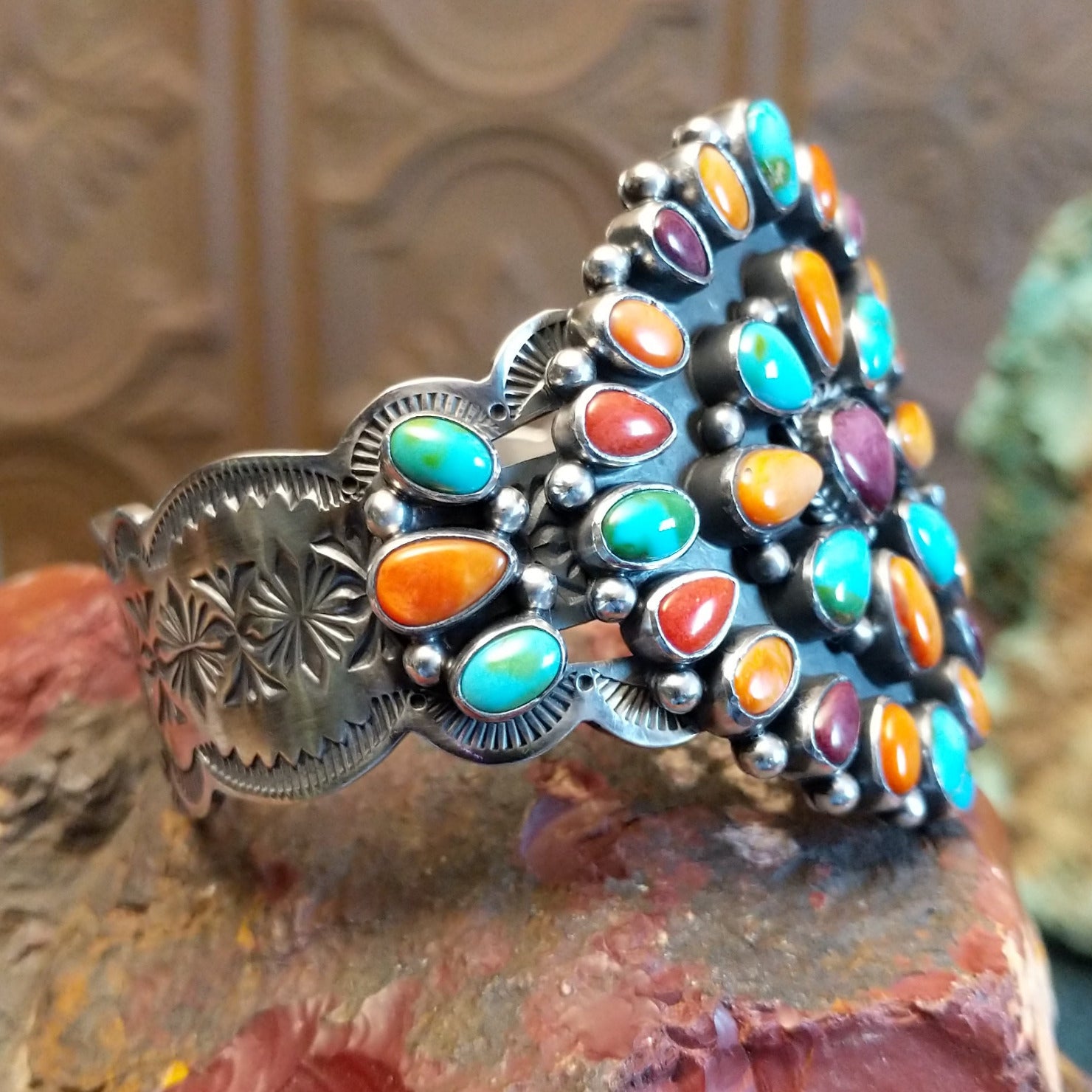 Sterling silver cuff bracelet with multistone assortment set in various bezels, framed by twisted rope and dotted accents.