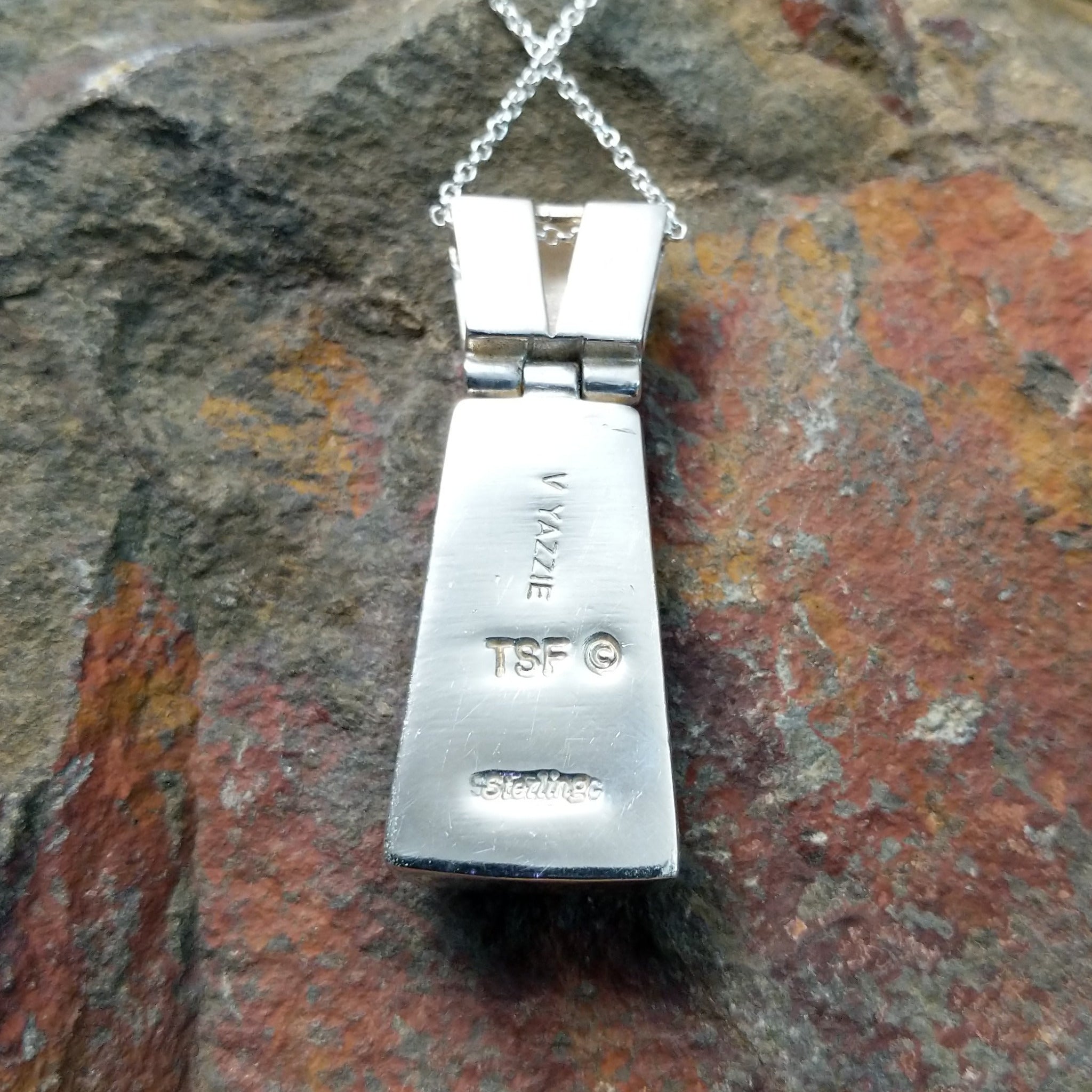 Handcrafted sterling silver multistone inlay pendant by Valerie Yazzie, featuring a colorful geometric inlay design with an articulated two-piece pendant; artisan and Sterling Silver stamp.