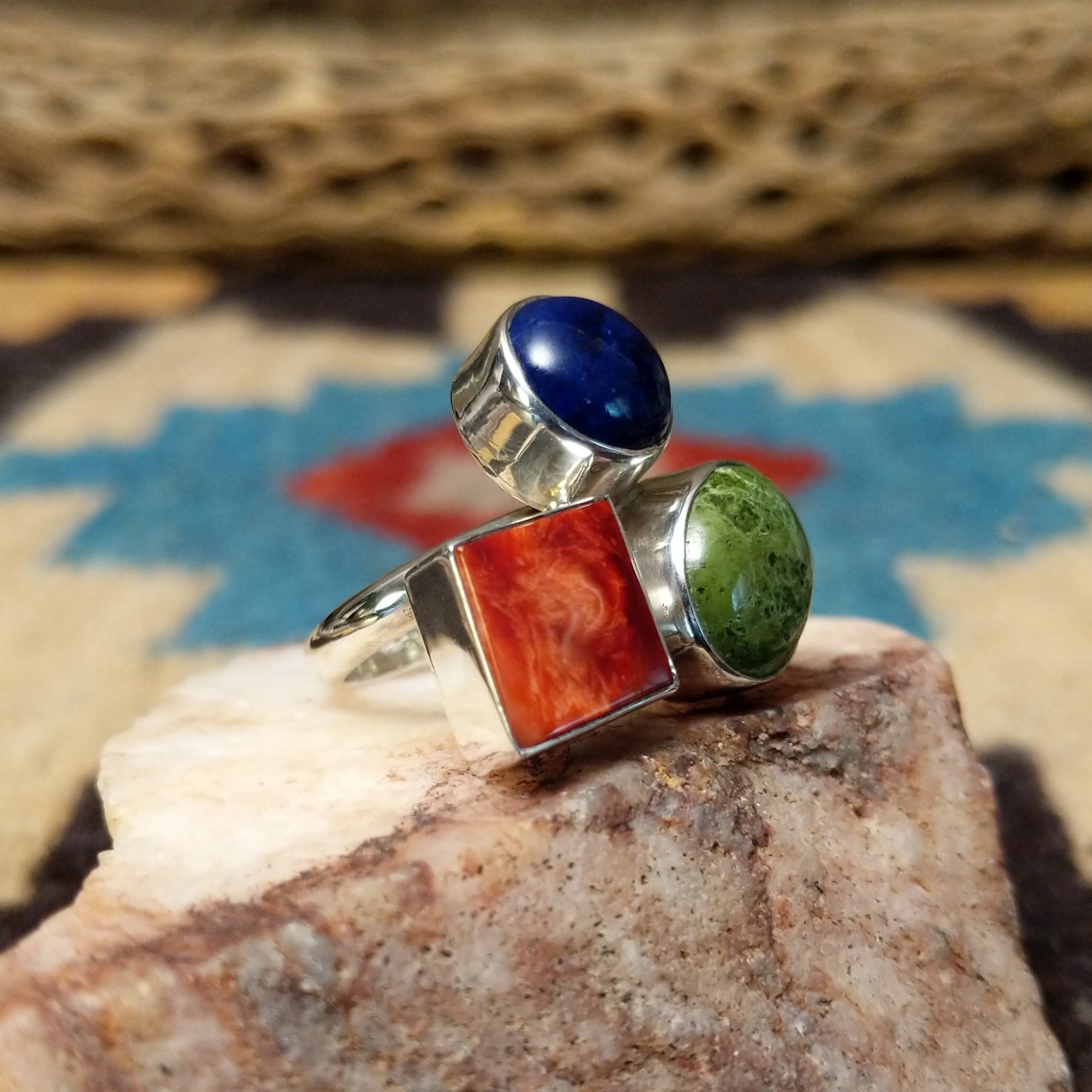 Multistone trio ring by Ann Curley, featuring blue lapis, green turquoise, and red spiny oyster shell set in a handcrafted sterling silver ring with a contemporary design. Side view.