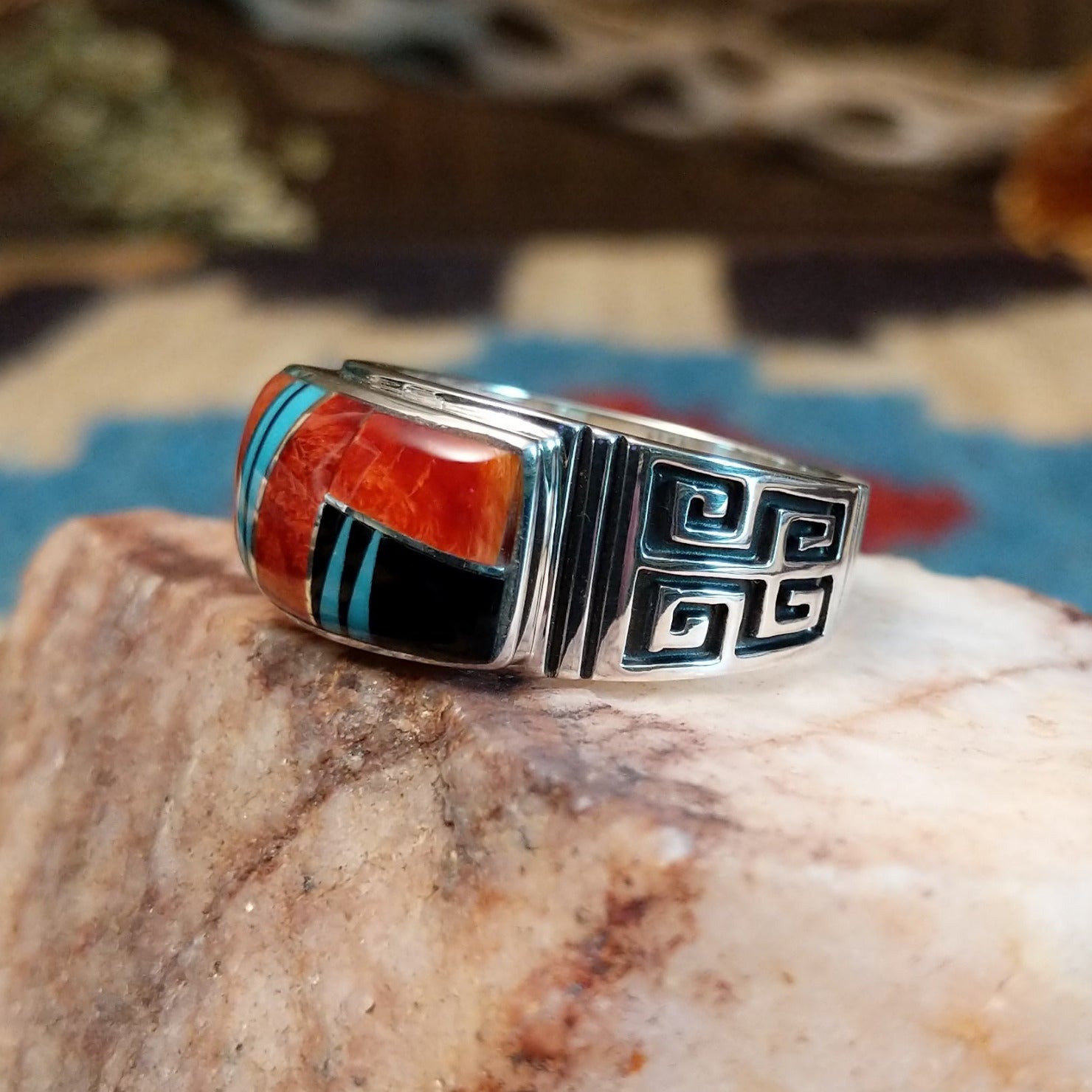 Sterling silver ring with multistone inlay and geometric stamping on the band.