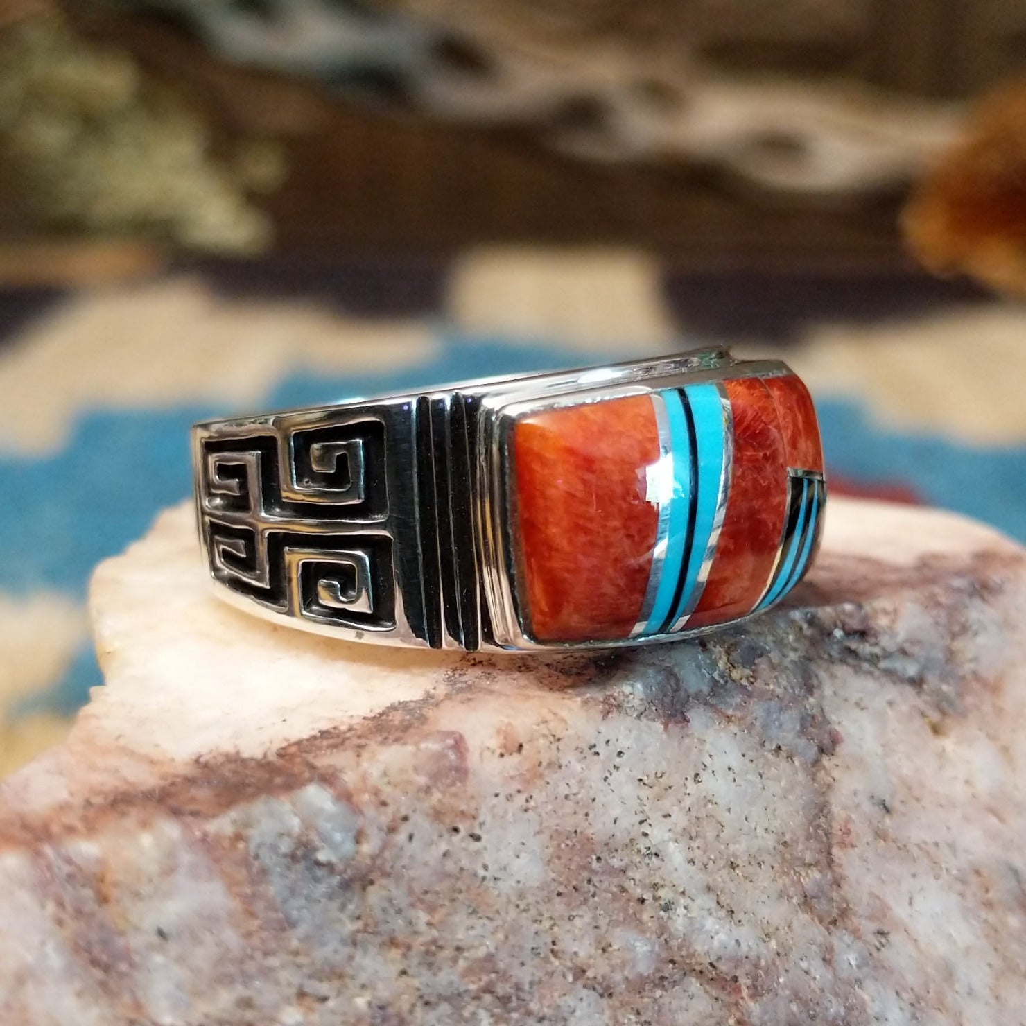 Sterling silver ring with multistone inlay and geometric stamping on the band.