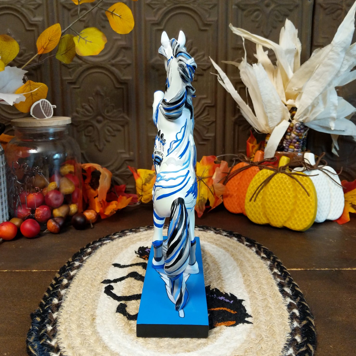 Resin pony painted white with Native American motif and contrasting blue paints.