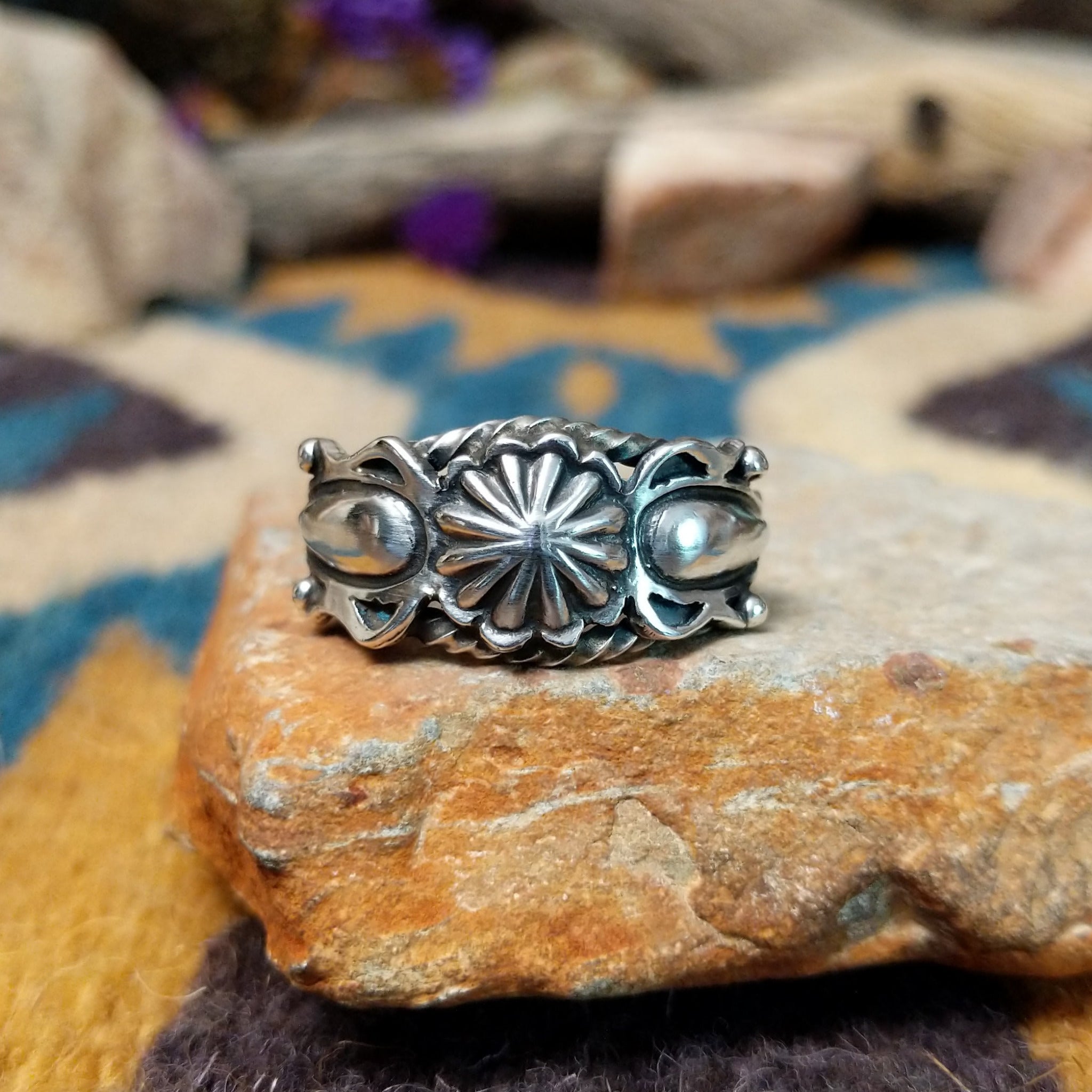 Navajo sterling silver ring with a hand-stamped floral design and polished silver accents.