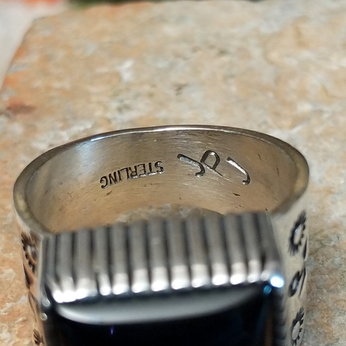 Navajo black onyx ring by J.P.J. with stamped silver band. Close up of the artist's stamped signature.