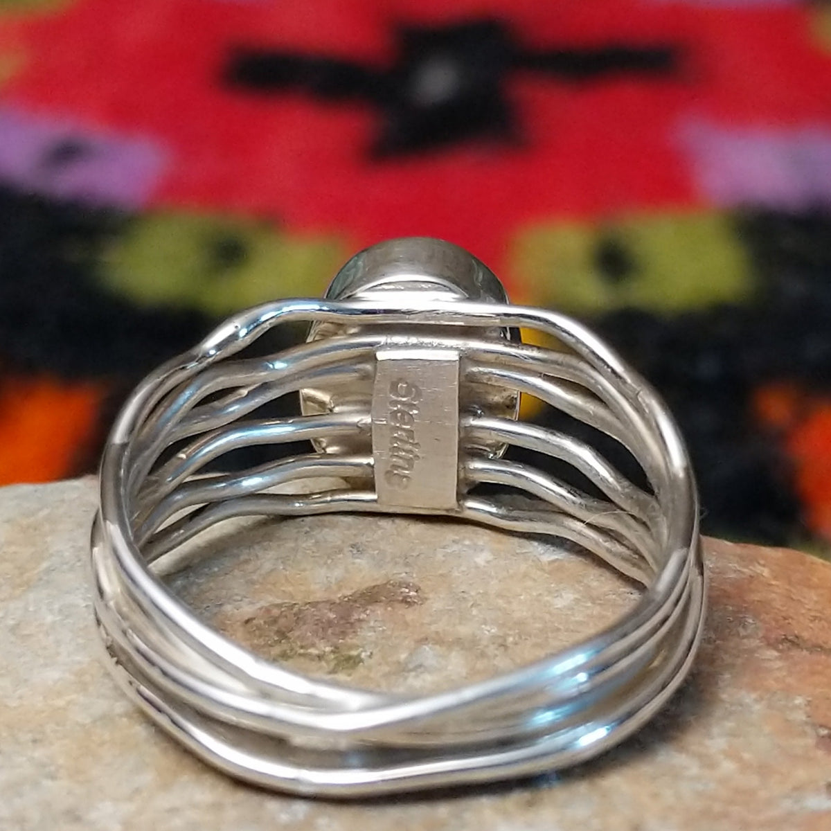 Navajo silver ring with polished black onyx and a multi-strand wavy band. Close up of the artist's stamped signature.