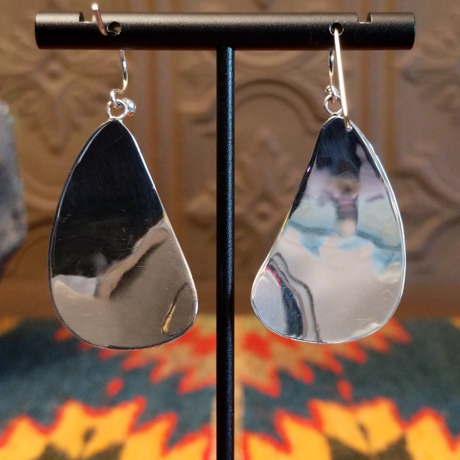 Sterling silver earrings with black onyx set in oval bezels, framed by the wavey silver settings and lined stamping.