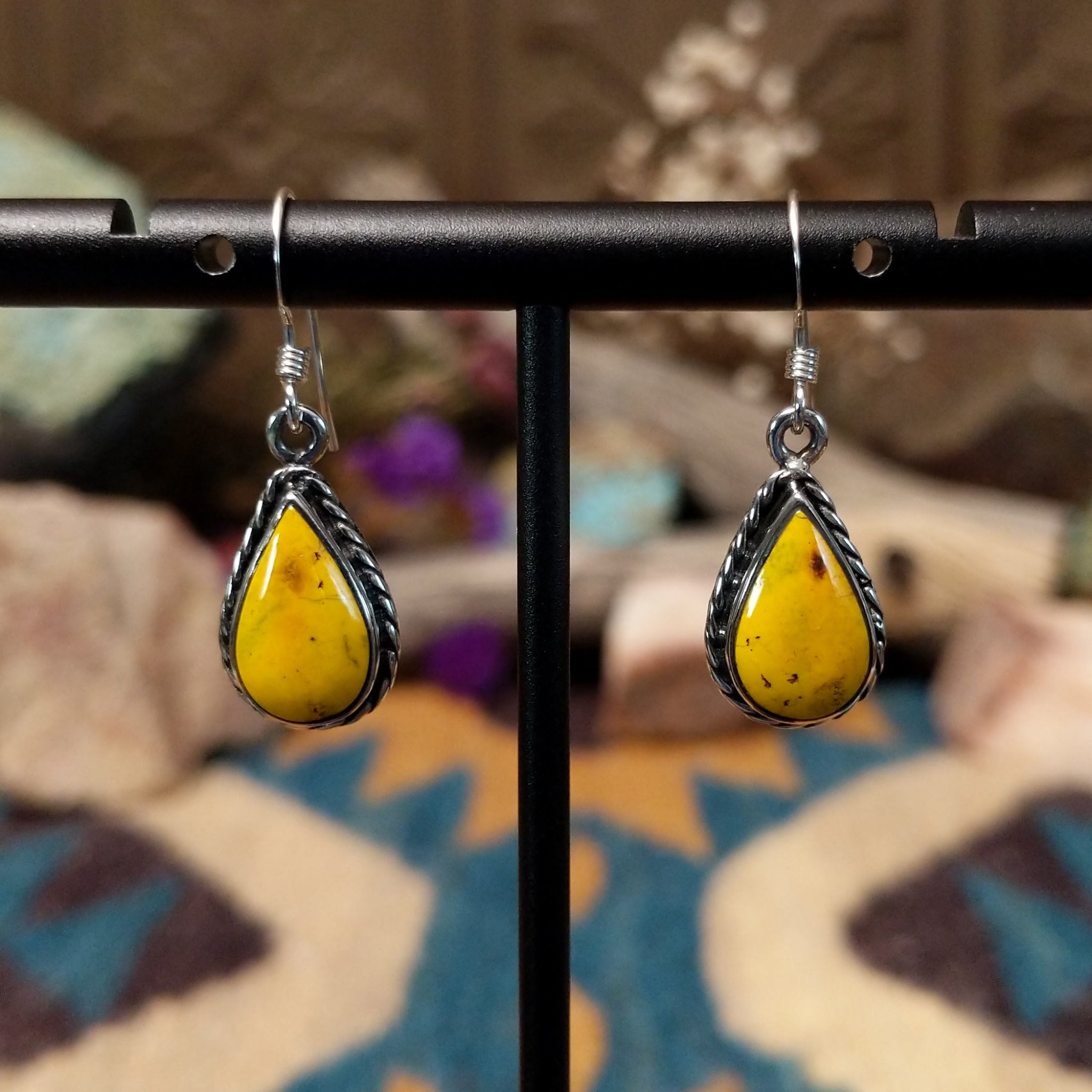 Handcrafted Navajo sterling silver teardrop earrings featuring vibrant Bumblebee Jasper cabochons with golden-yellow tones, natural earthy inclusions, and twisted rope border detailing.
