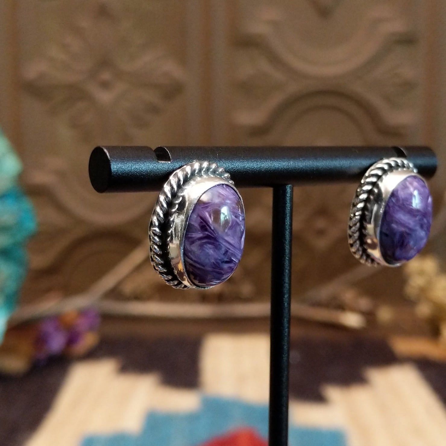 Sterling silver earrings with charoite set in oval bezels, framed by twisted rope accents.