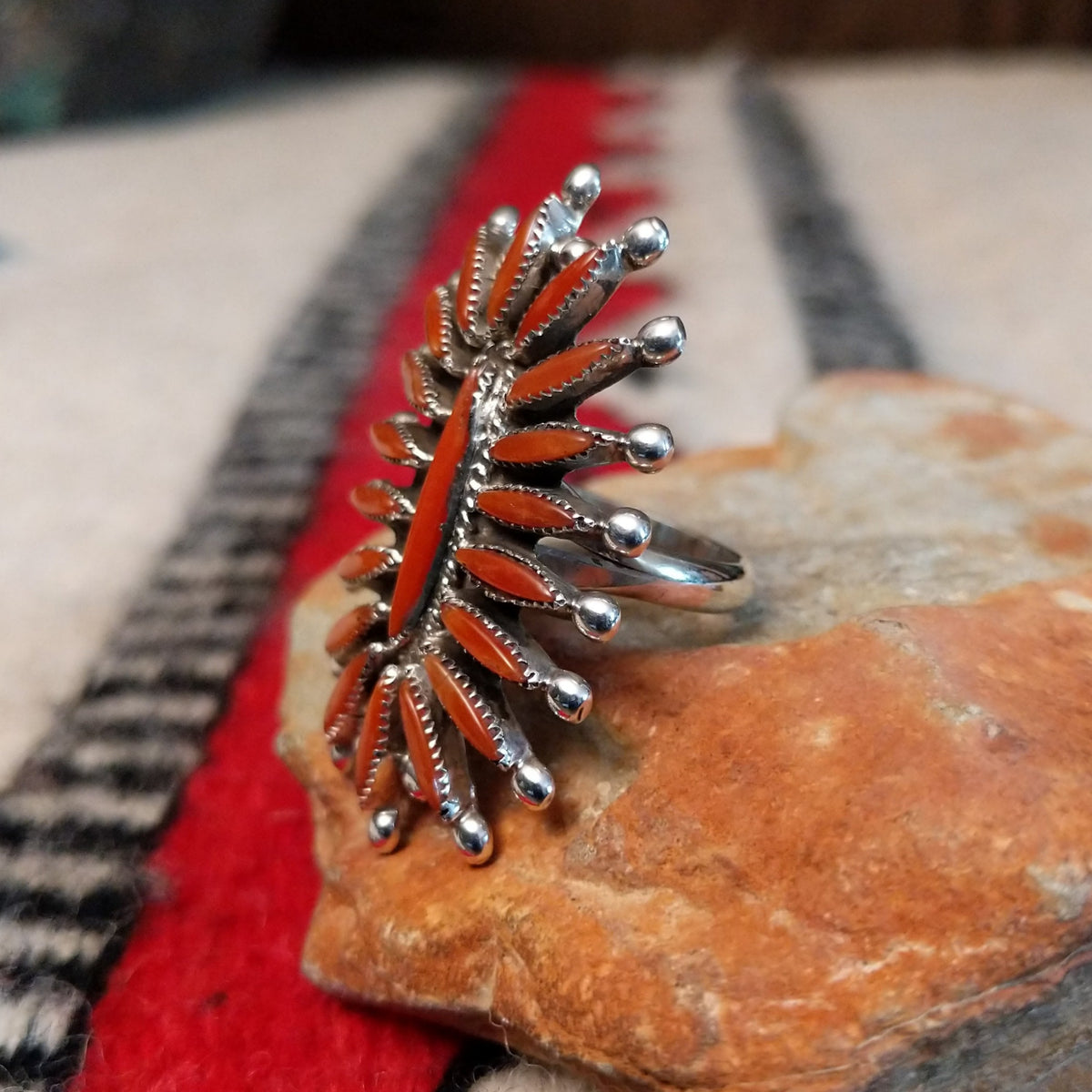 Navajo silver ring with radiating coral stones and silver drops.