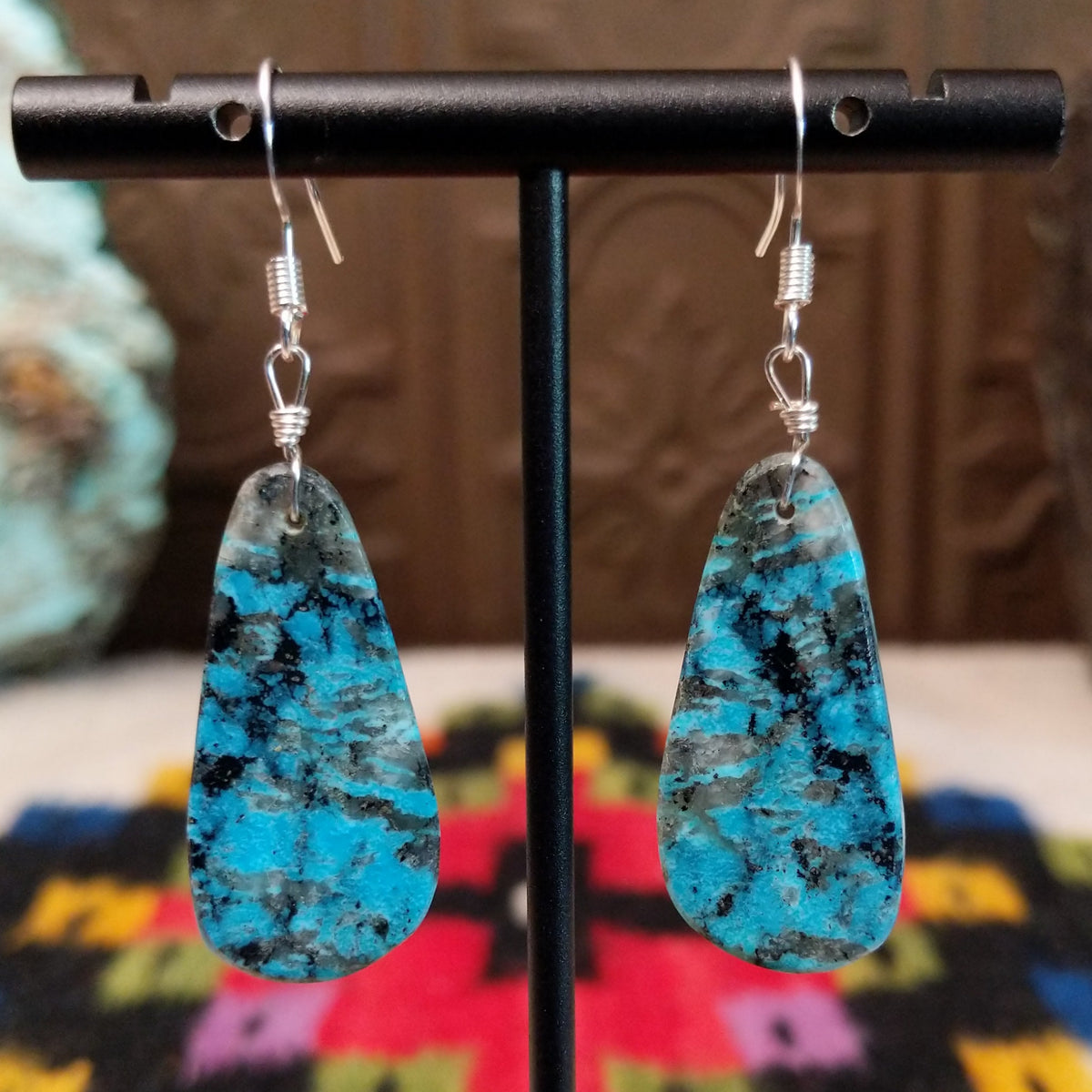 Navajo Dark Matrix Slab Turquoise Earrings featuring elongated blue turquoise stones with bold black and gray matrix patterns, suspended from silver hooks.