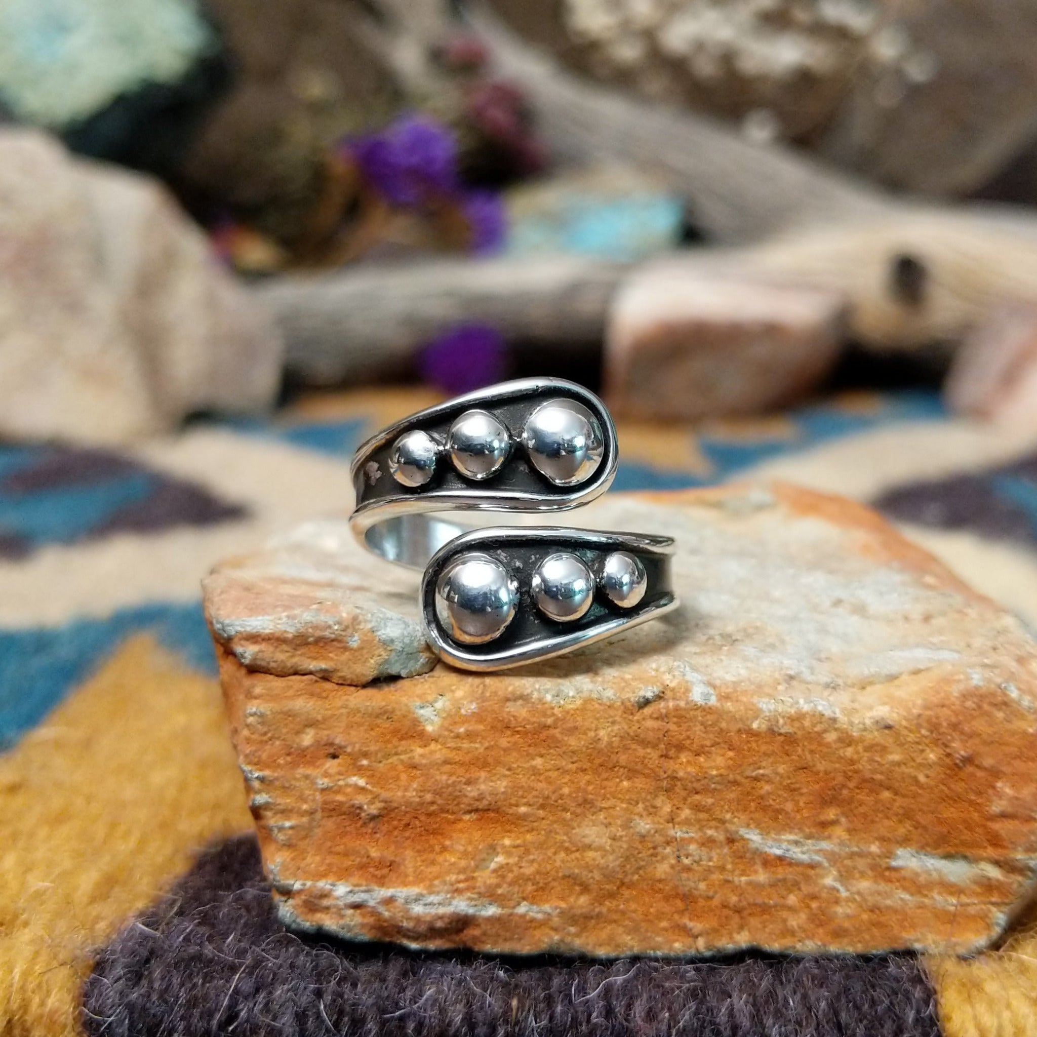 Handcrafted Navajo sterling silver bypass ring featuring graduated polished silver domes set in oxidized open-ended bezels, creating a modern Southwestern statement design.