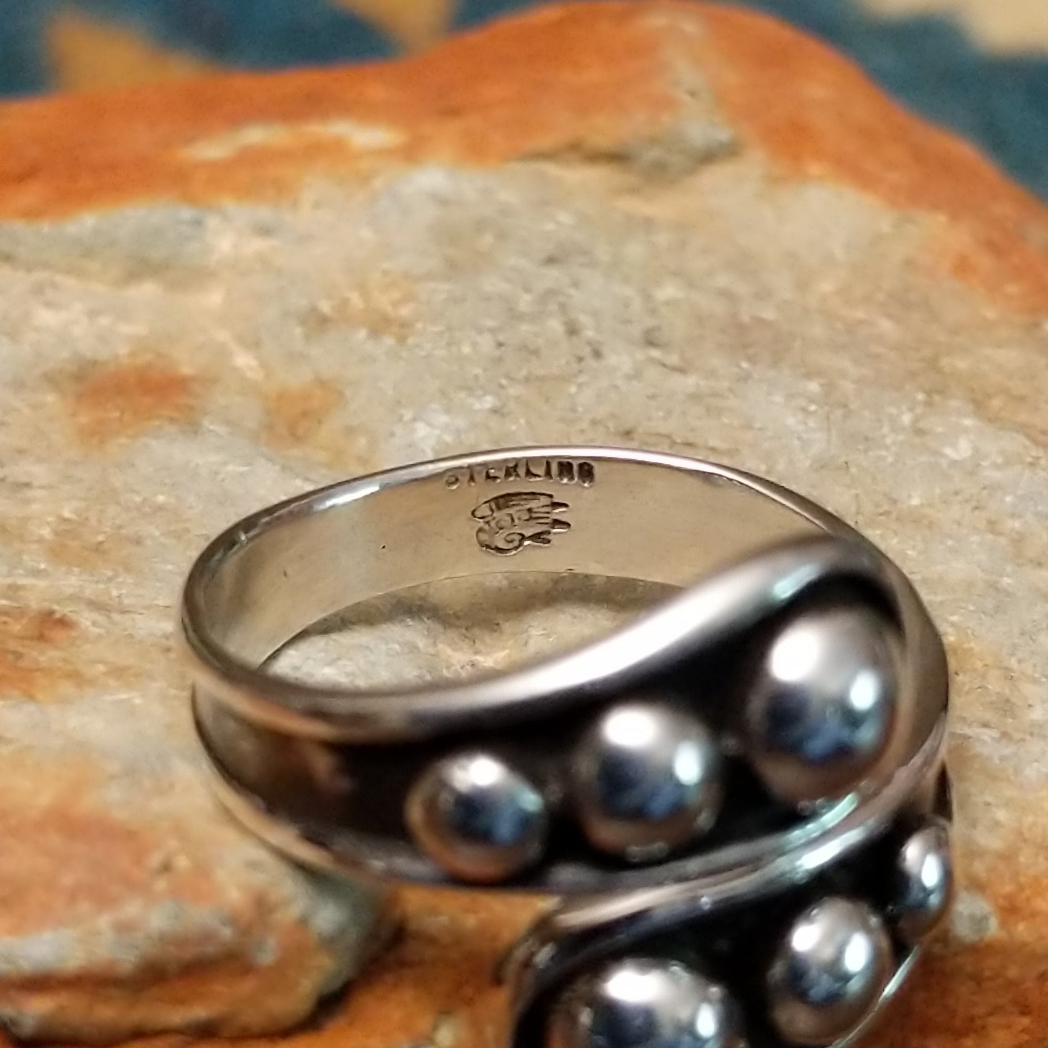 Handcrafted Navajo sterling silver bypass ring featuring graduated polished silver domes set in oxidized open-ended bezels, creating a modern Southwestern statement design; artisan and Sterling Silver stamp.