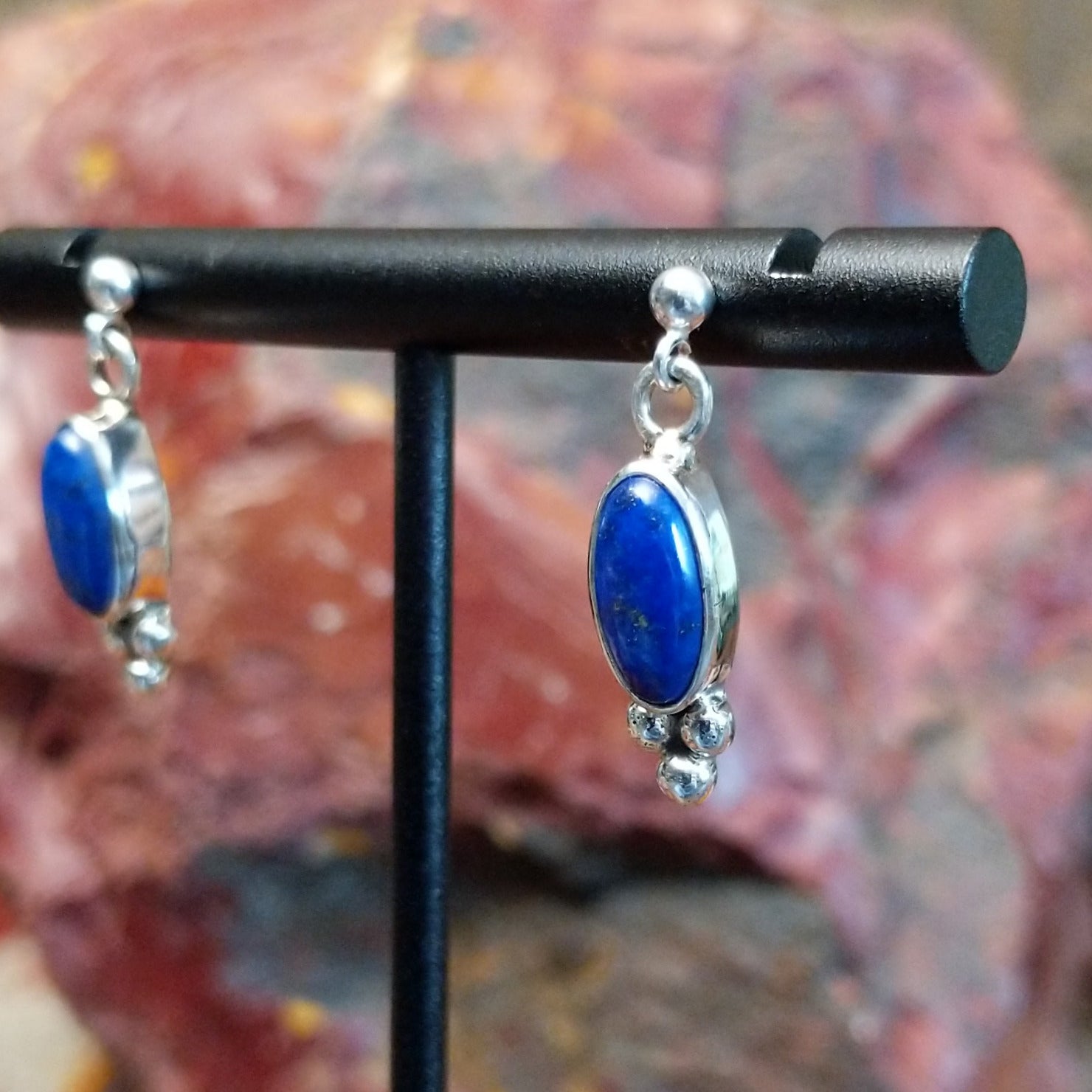 Sterling silver post earrings with lapis set in the bezels, framed by dotted accents.
