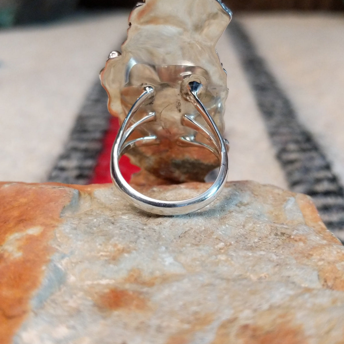 Navajo silver ring with layered feathers, flowers, and curled wire accents.