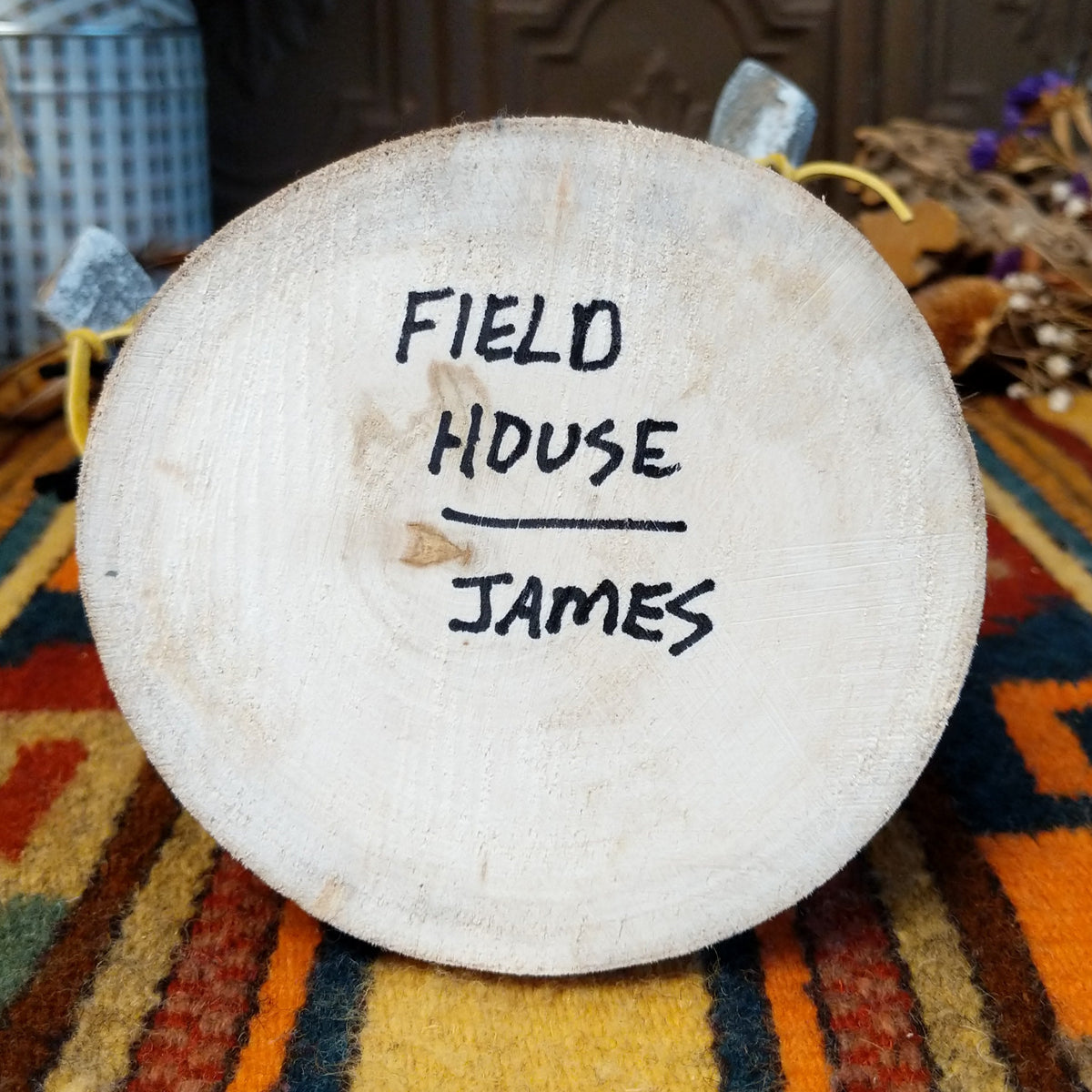Underside of Navajo Field House Kachina doll base with handwritten figure name and artist surname.