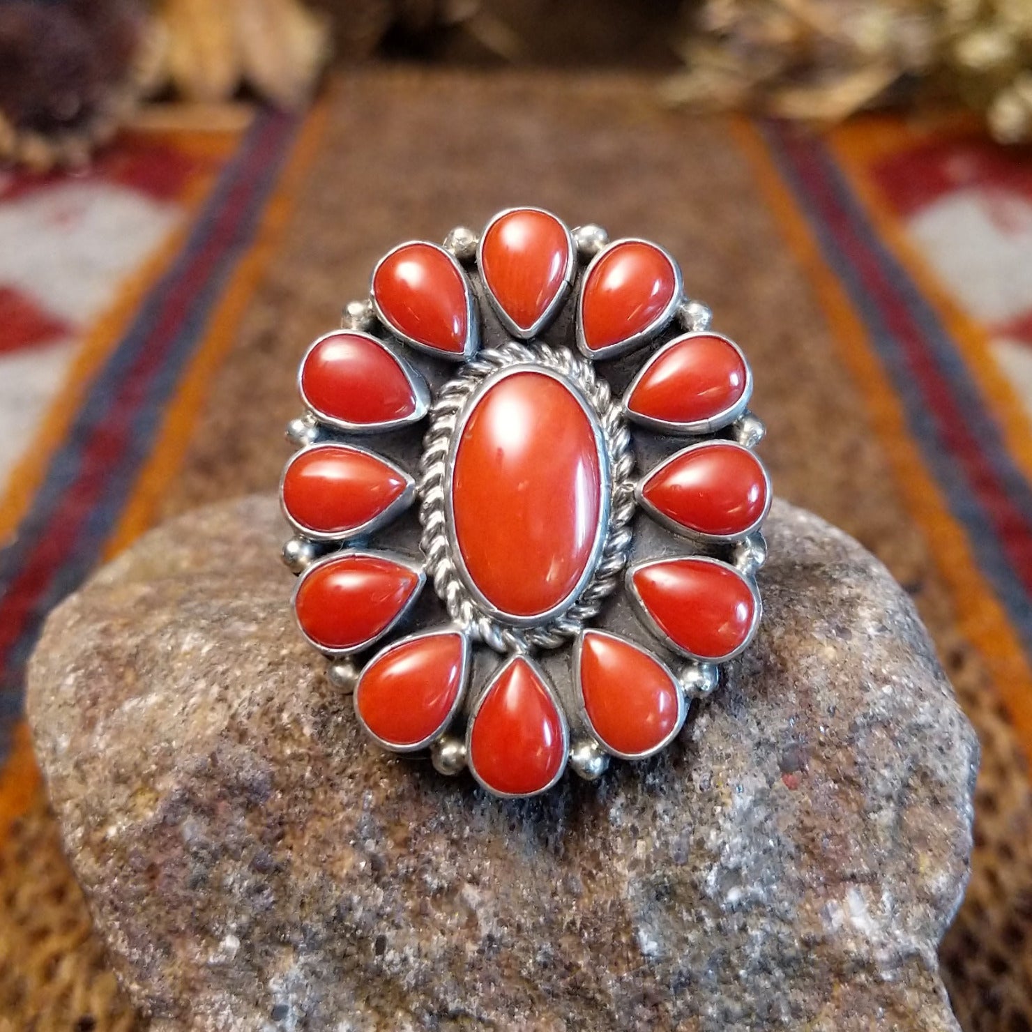 Sterling silver ring with coral set in the bezels creating a floral like motif and twisted rope accents around the center bezel.