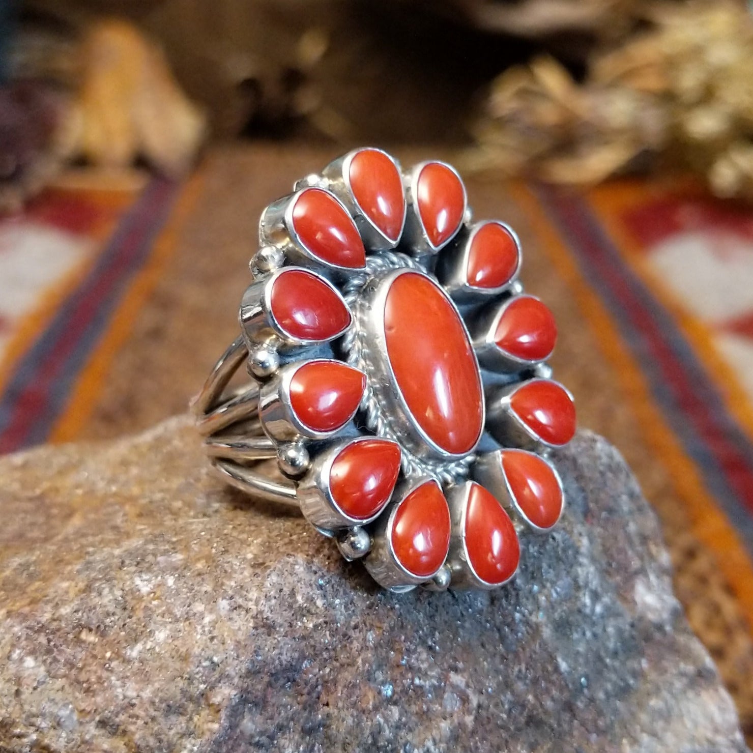 Sterling silver ring with coral set in the bezels creating a floral like motif and twisted rope accents around the center bezel.