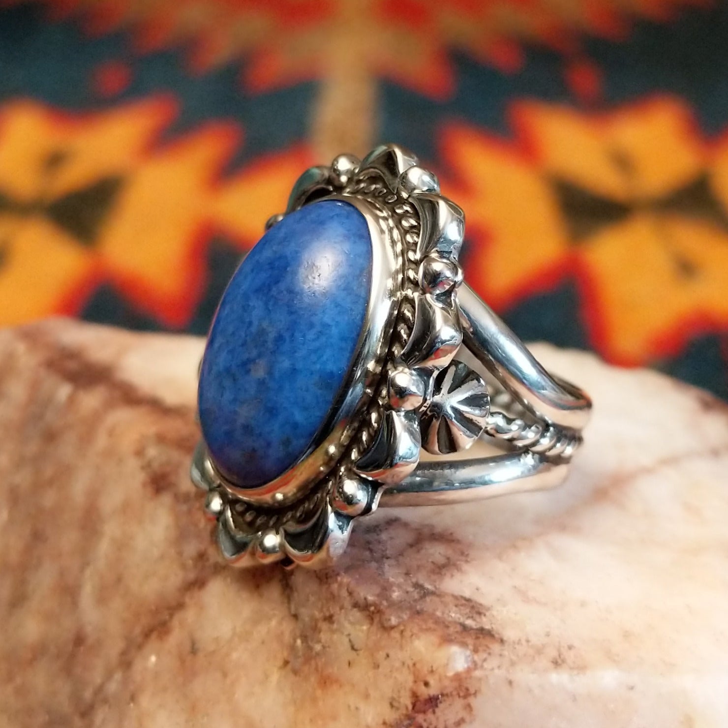 Sterling silver ring with denim lapis set in the bezel, framed by ornate and frilled silverwork.