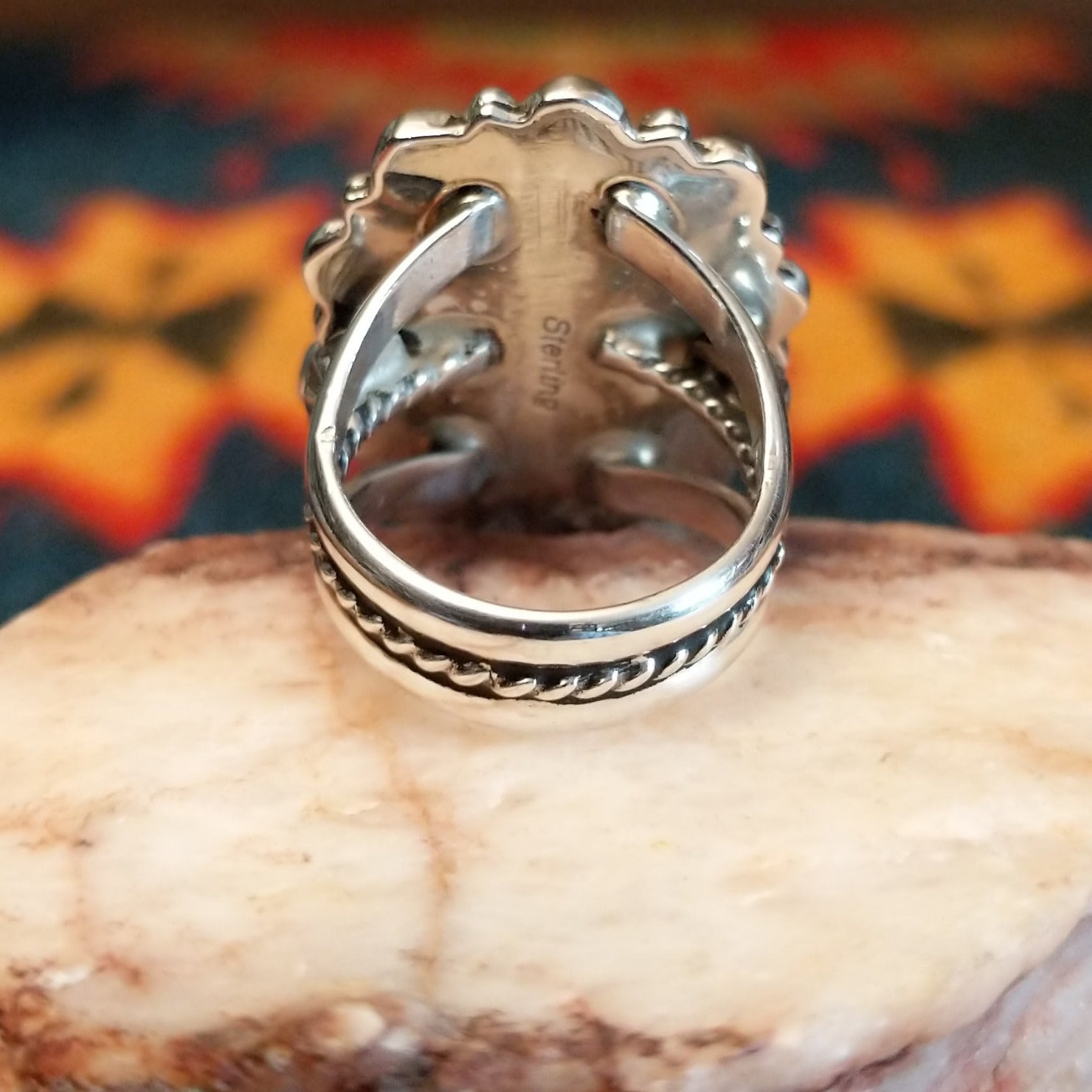 Sterling silver ring with denim lapis set in the bezel, framed by ornate and frilled silverwork.