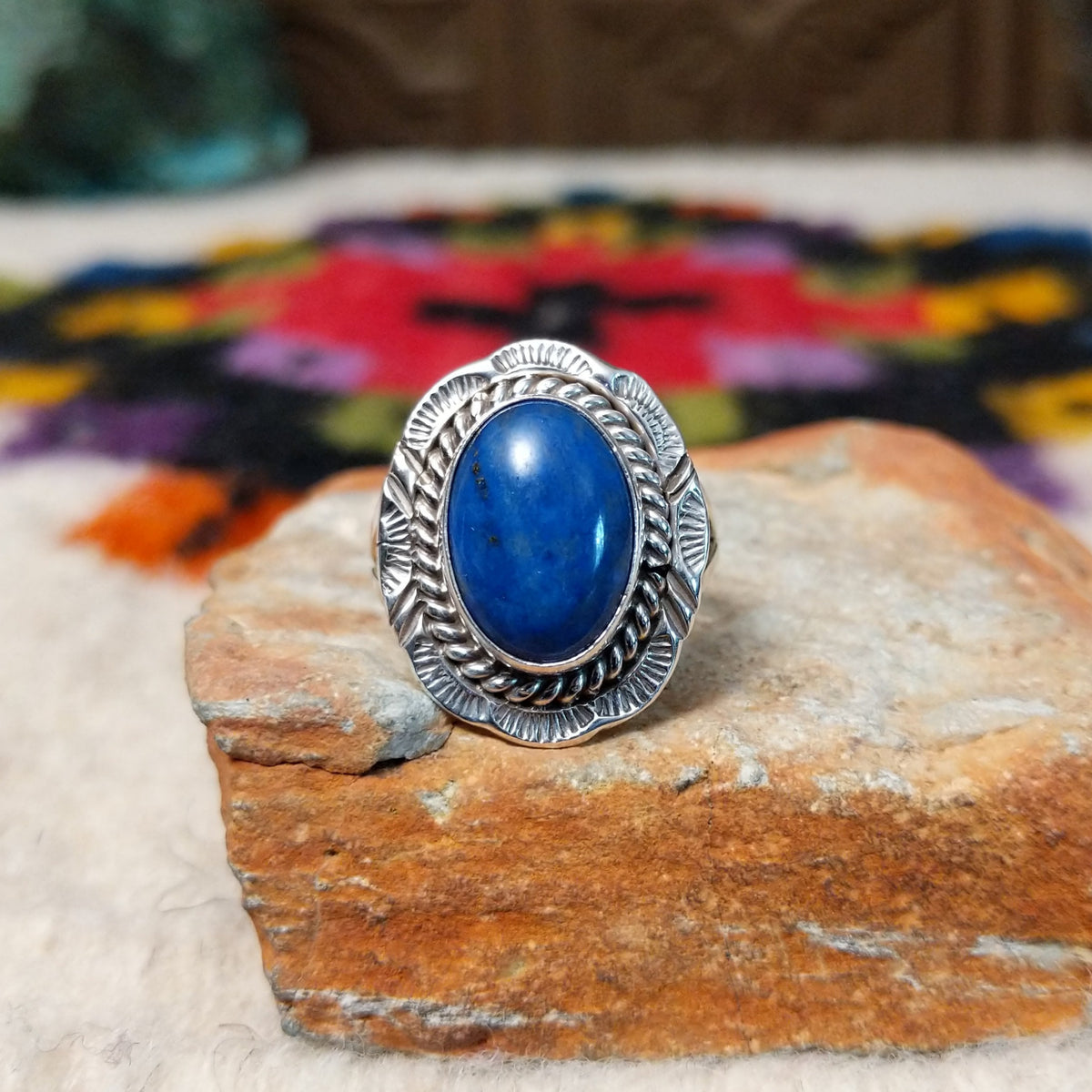 Navajo lapis ring by P. with oval blue stone, twisted silver border, and stamped details.