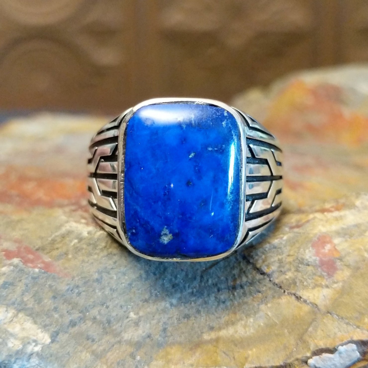 Sterling silver ring with lapis set in the rectangular bezel and geometric designs on the band.