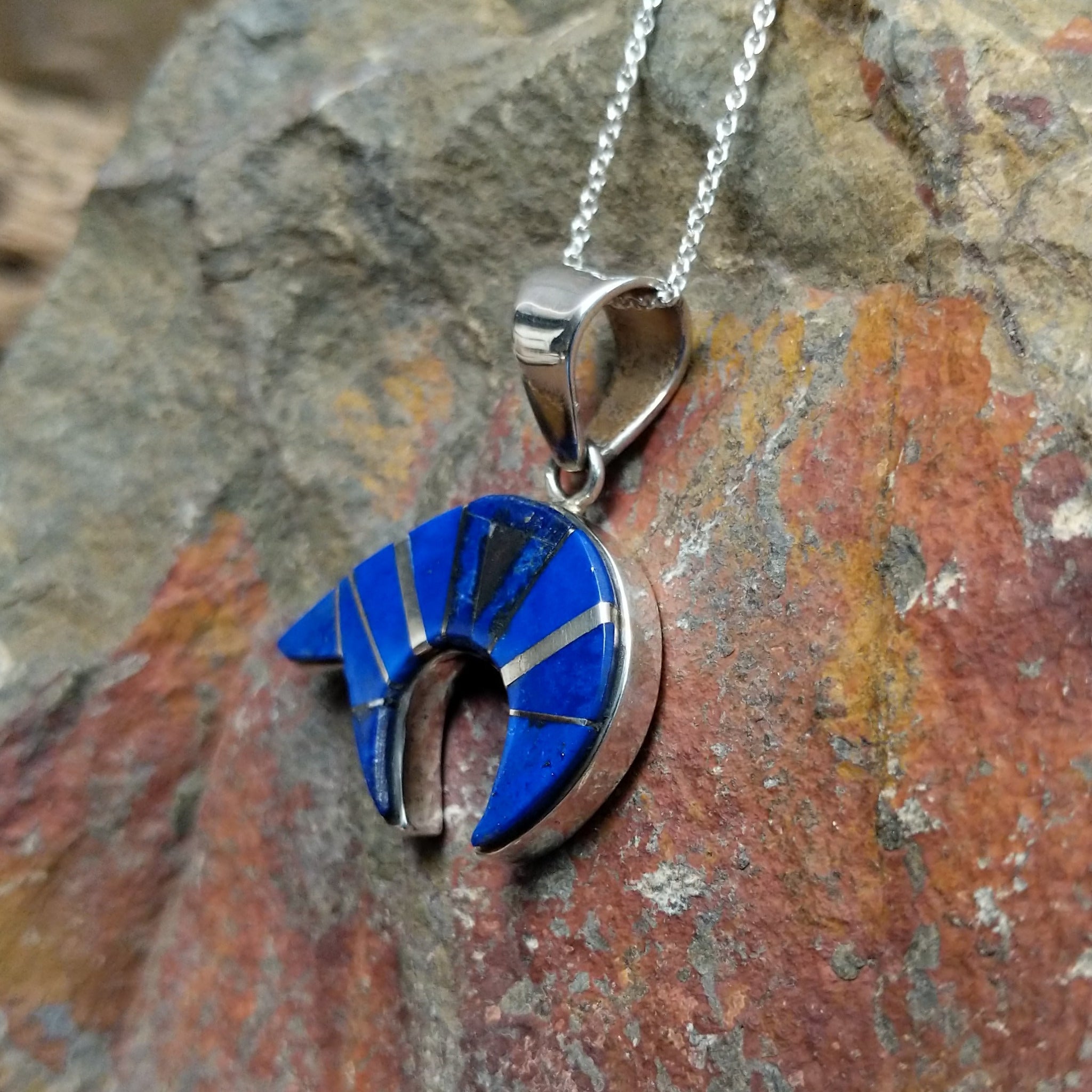 Handcrafted sterling silver lapis spirit bear pendant by T.G., featuring a traditional Navajo bear design; side view.