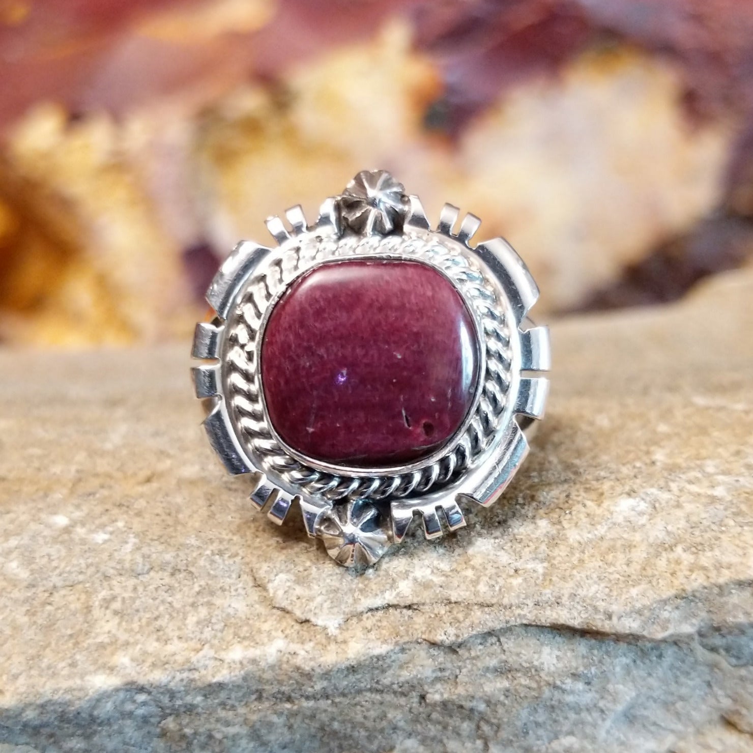 Purple spiny oyster set in an ornate bezel with twisted rope, stars, and various incisions.