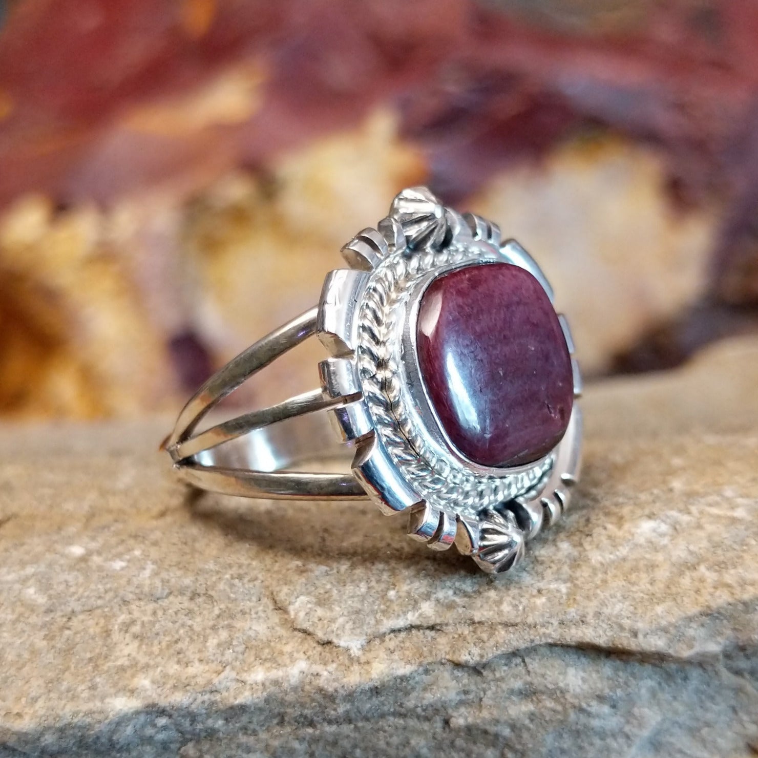 Purple spiny oyster set in an ornate bezel with twisted rope, stars, and various incisions.