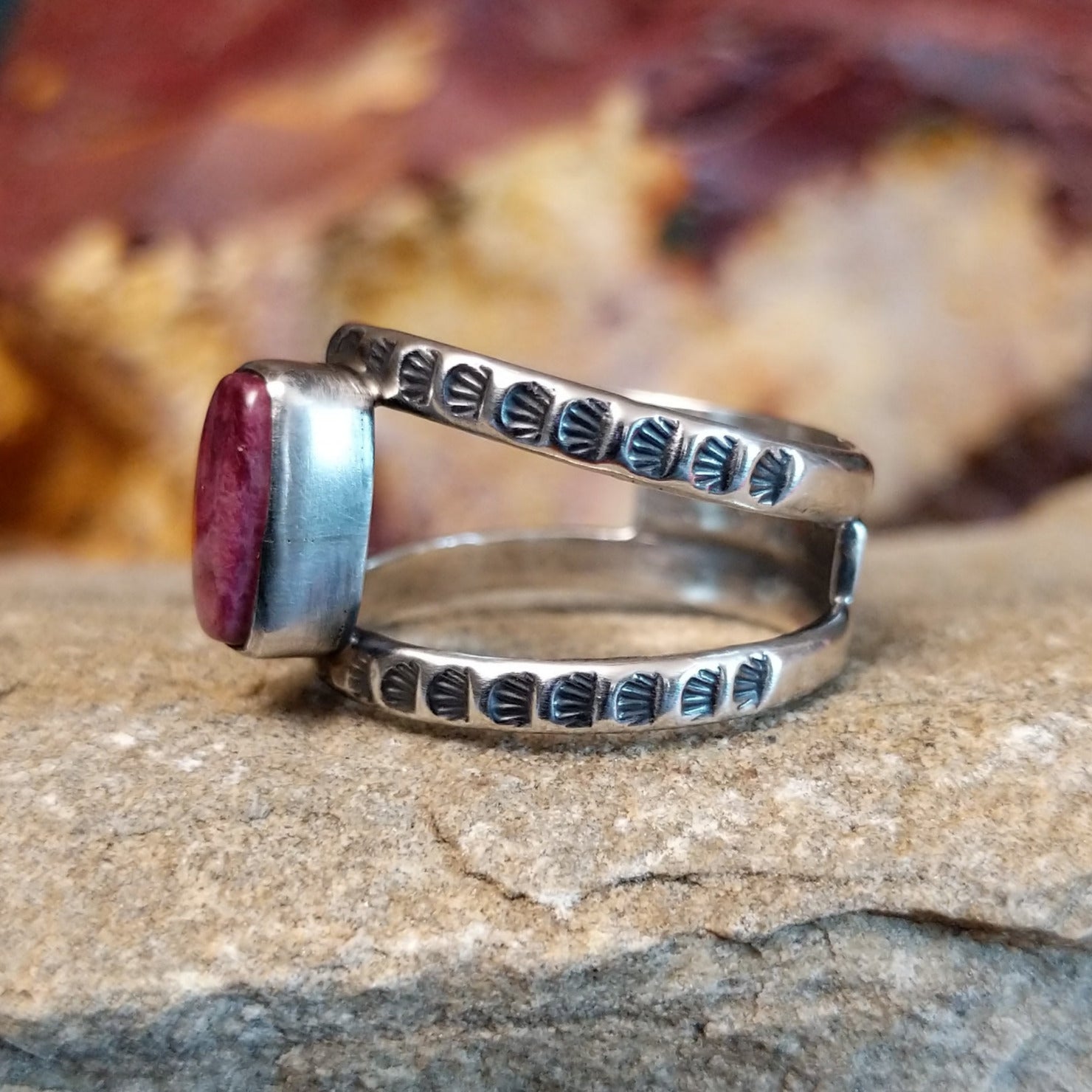Open, layered sterling silver band with stamping and a purple spiny oyster centerpiece.