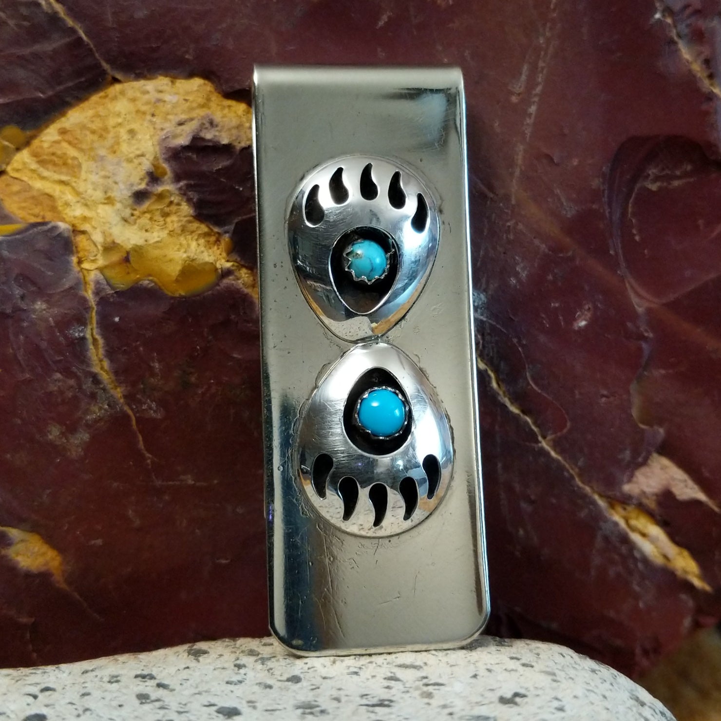 Two shadowbox bear claws set on the sterling silver face.