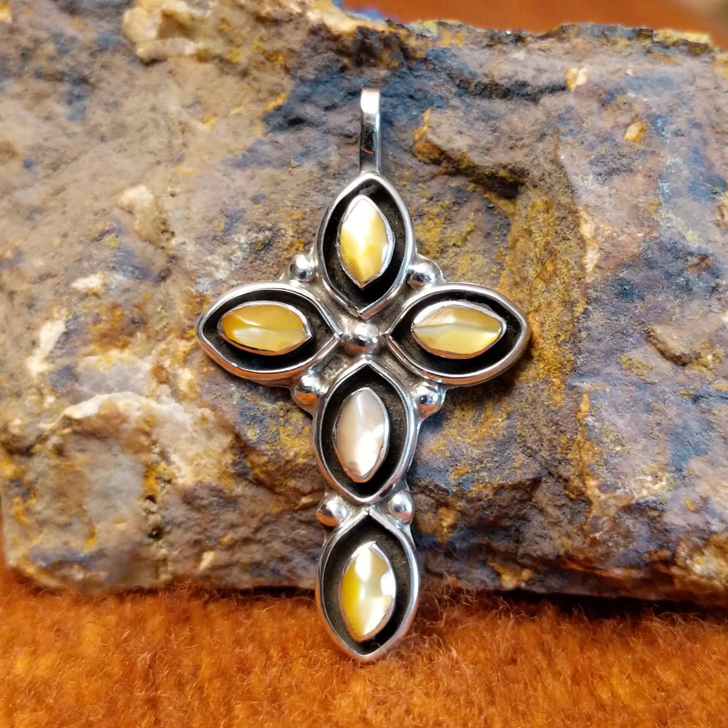 Yellow mussel shell set in sterling silver shadowbox settings shaped as a cross.