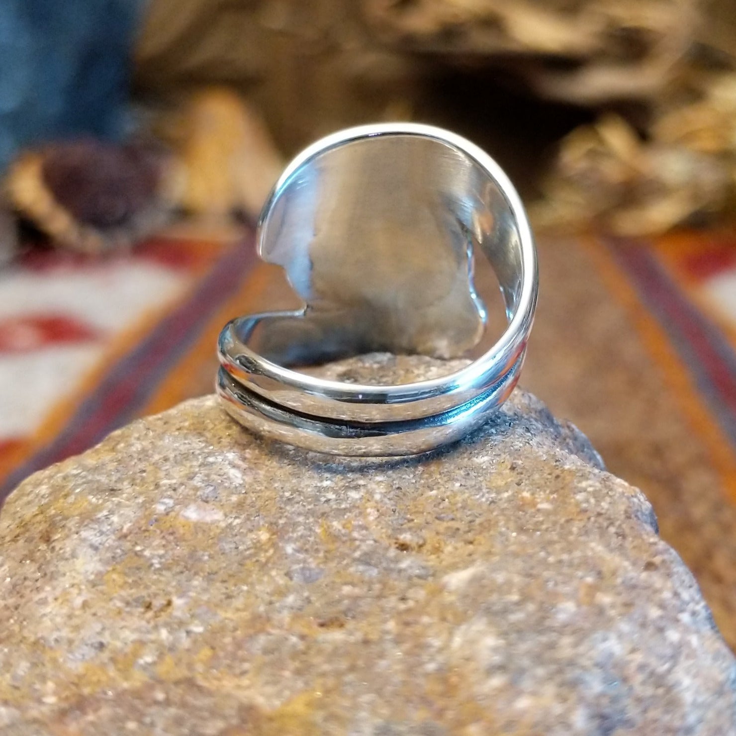 Sterling silver ring with malachite set in the bezel and framed by swirling silverwork.