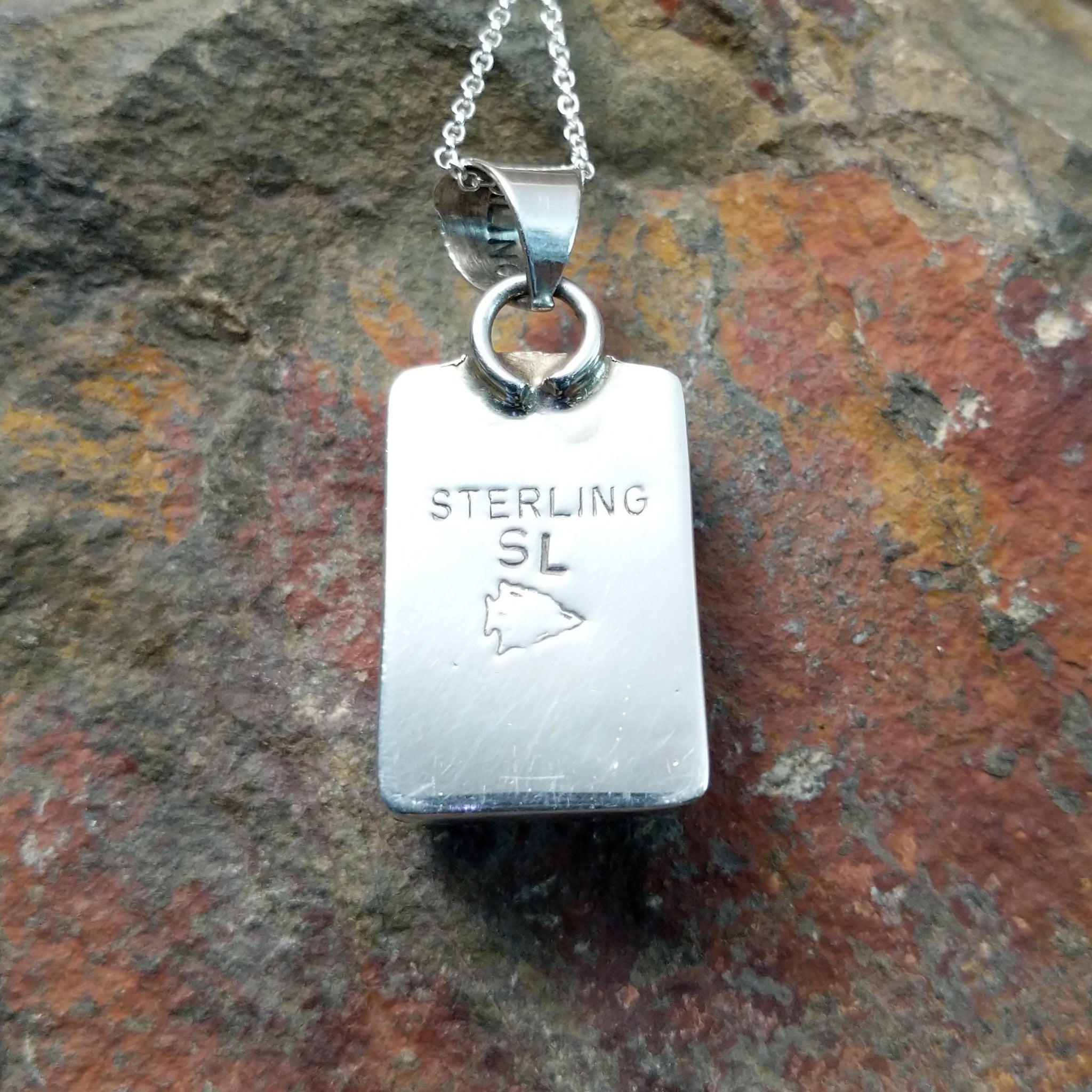 Handcrafted sterling silver compressed stone inlay pendant by S.L., featuring a colorful geometric Navajo design; artisan and Sterling Silver stamp.