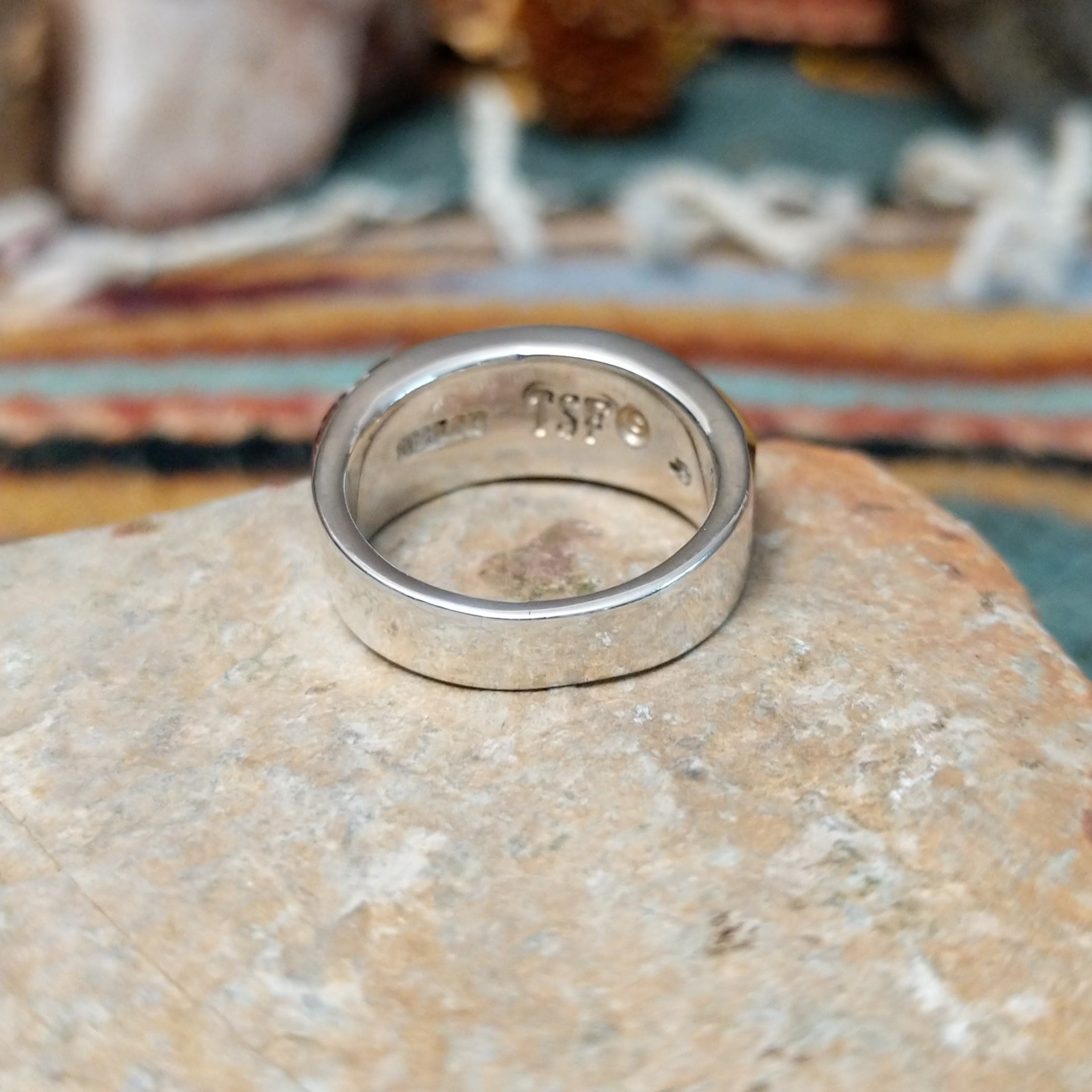 Navajo sterling silver ring by J.C. featuring geometric multistone inlay with black onyx, tiger’s eye, and assorted natural stones separated by silver dividers; underside view.